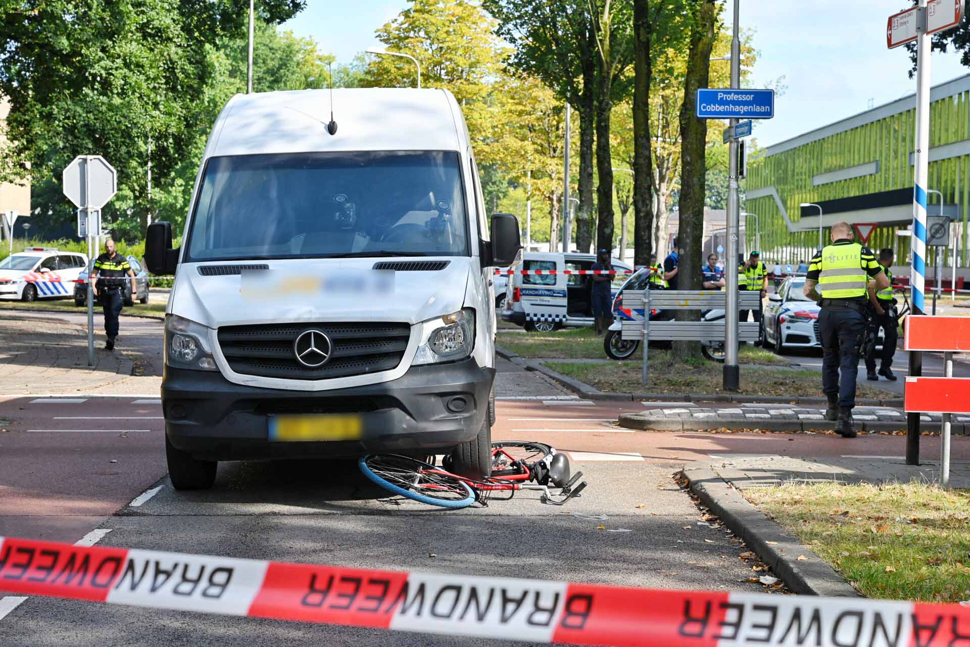 Fietsster bekneld onder bestelbus na aanrijding