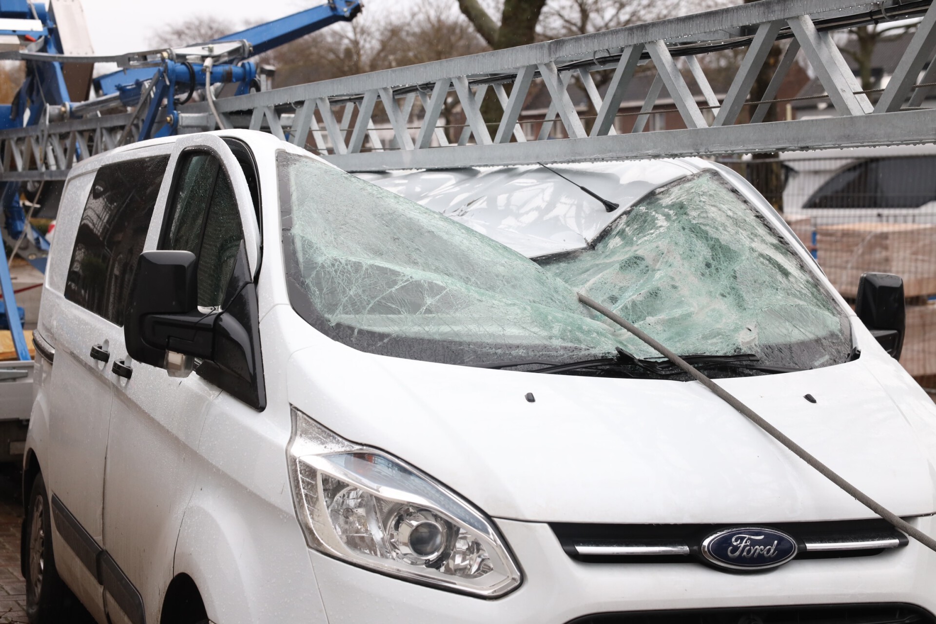 Hijskraan valt om en belandt op busje