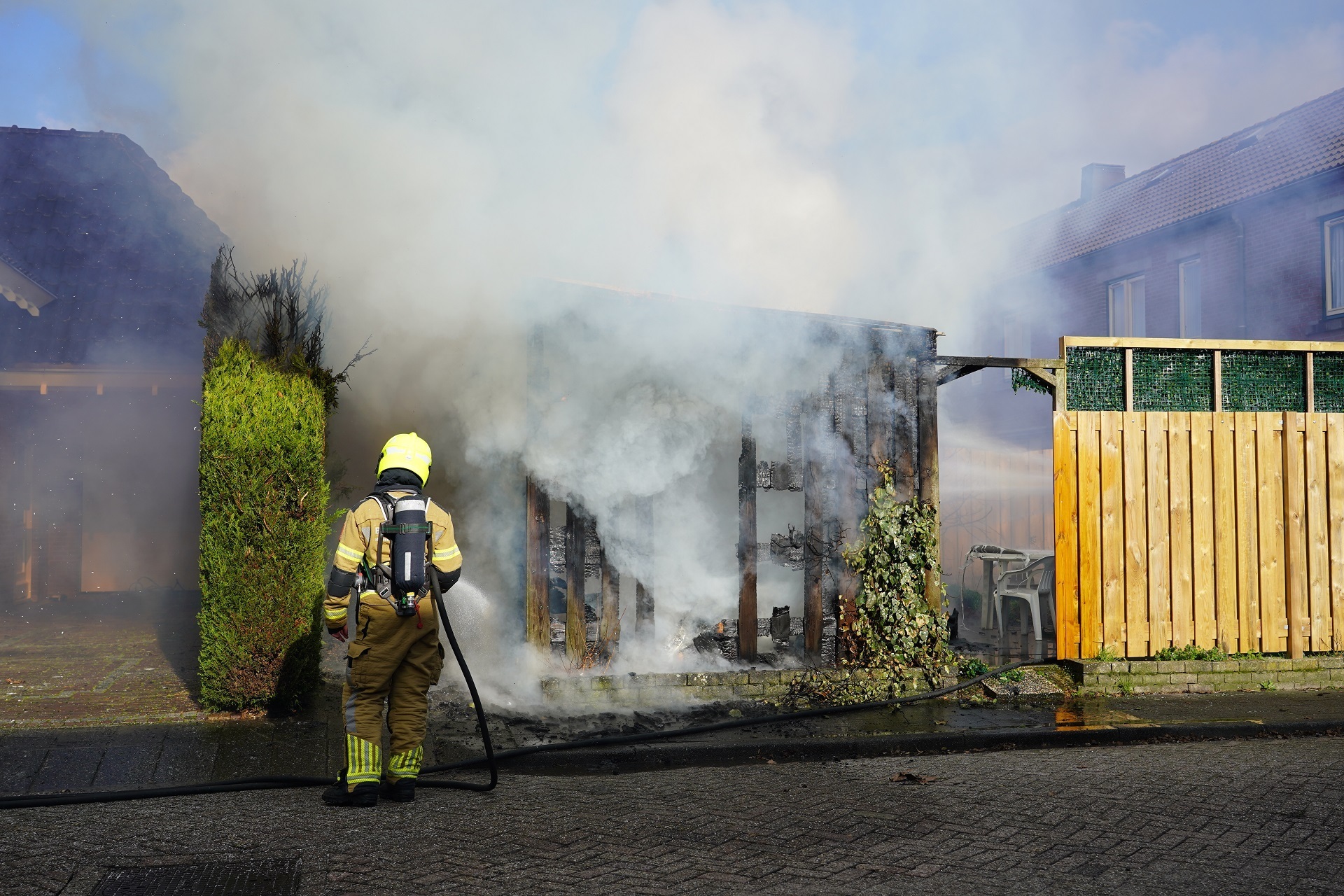Schuur in brand achter woning, brandweer voorkomt overslag