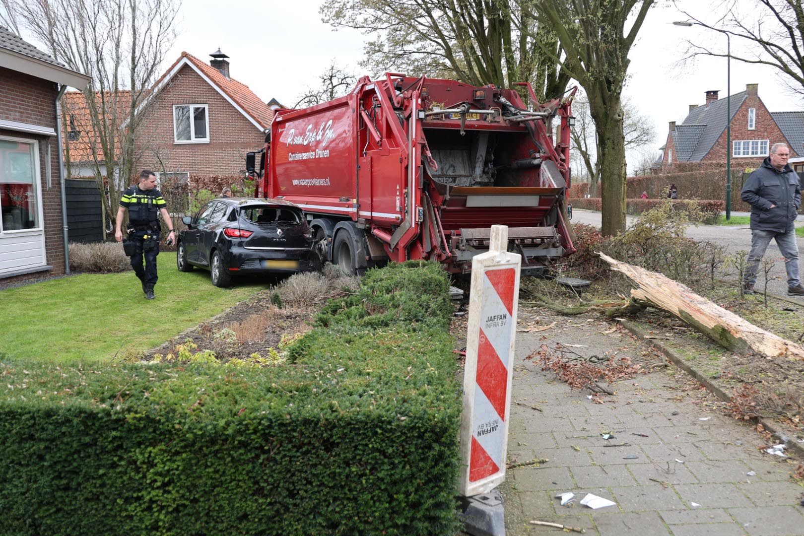Chauffeur vuilniswagen wordt onwel, botst tegen auto en rijdt boom omver
