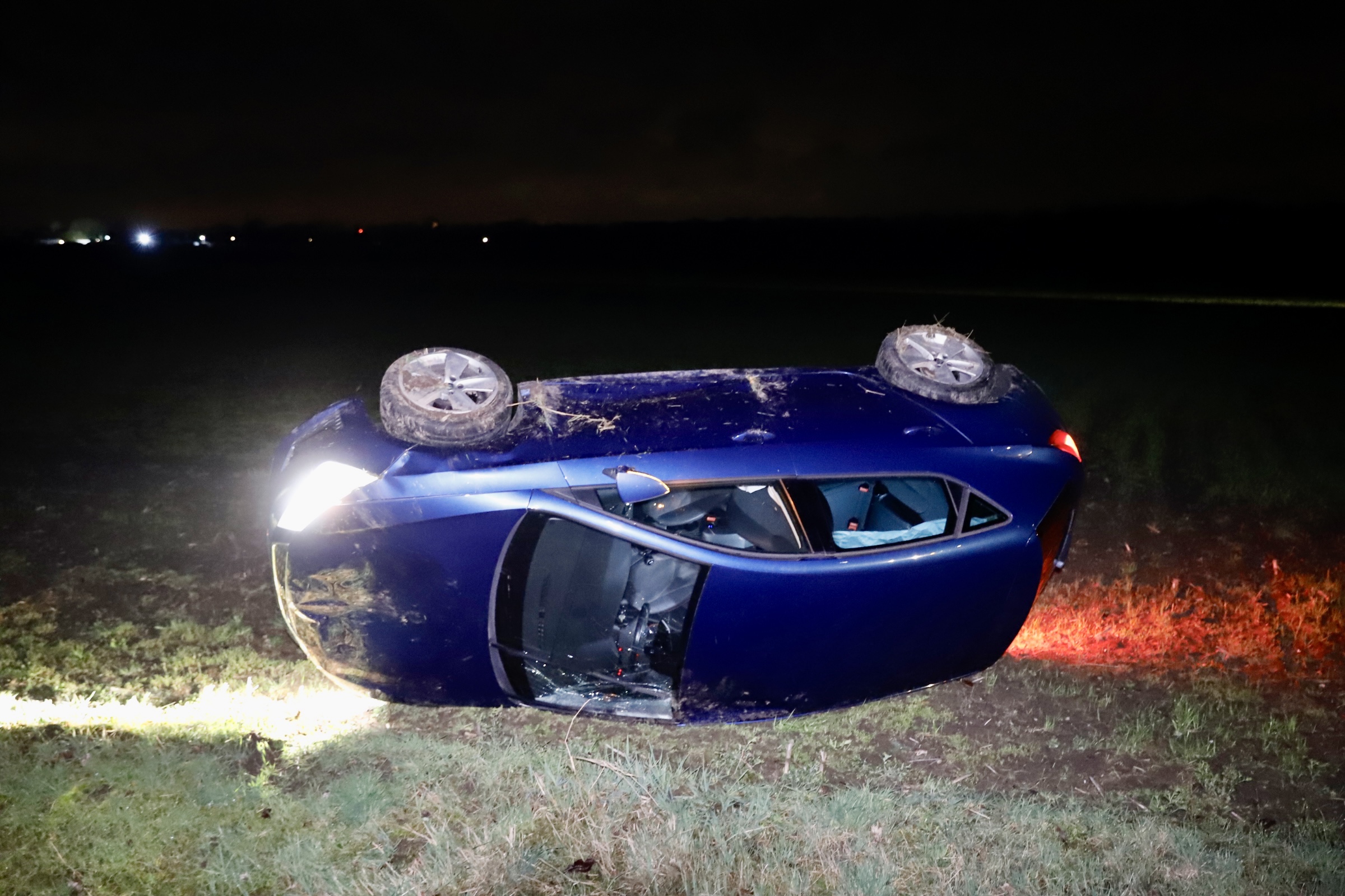 Auto raakt van de weg en belandt in weiland