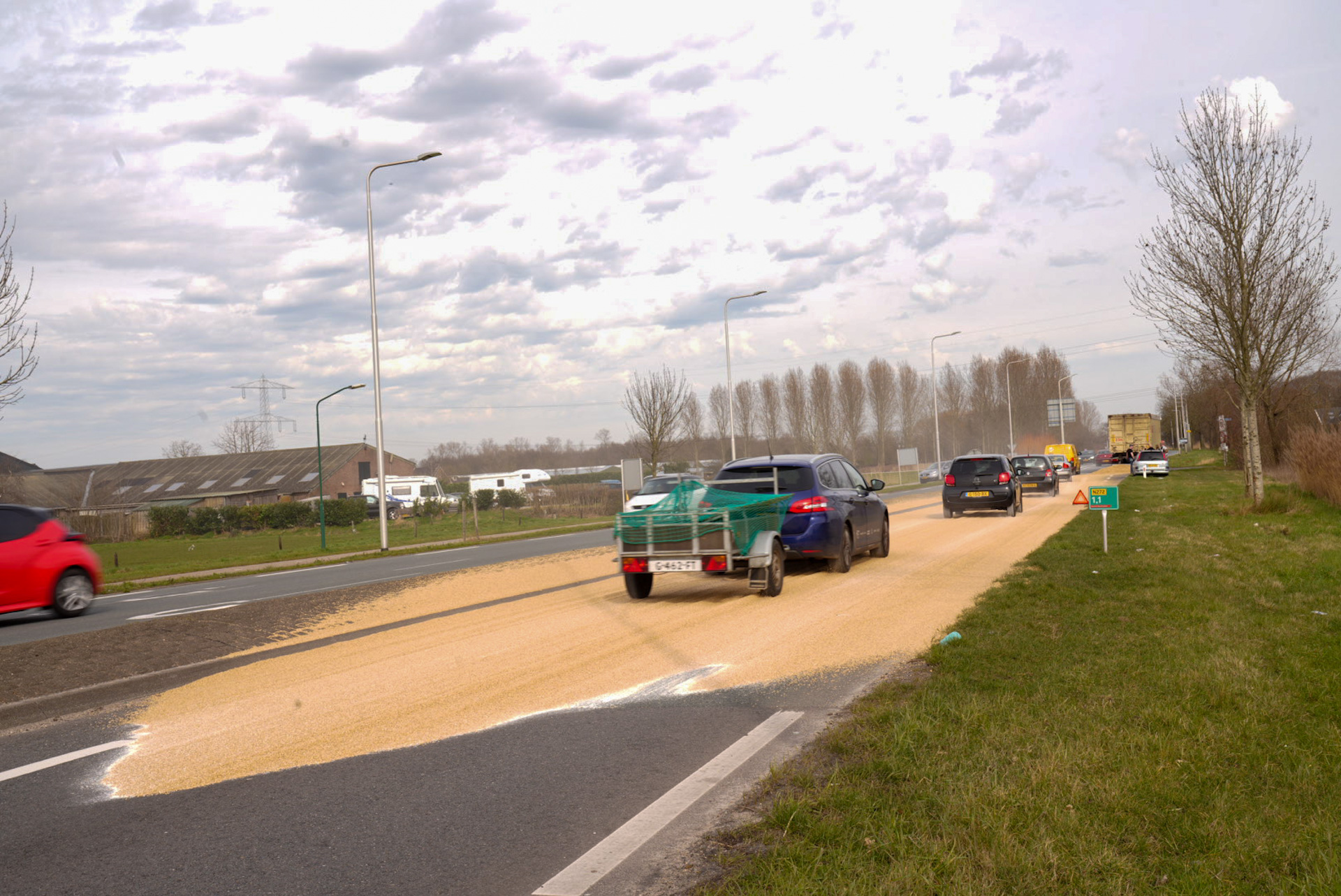 Deur van vrachtwagen vliegt open en verliest graan