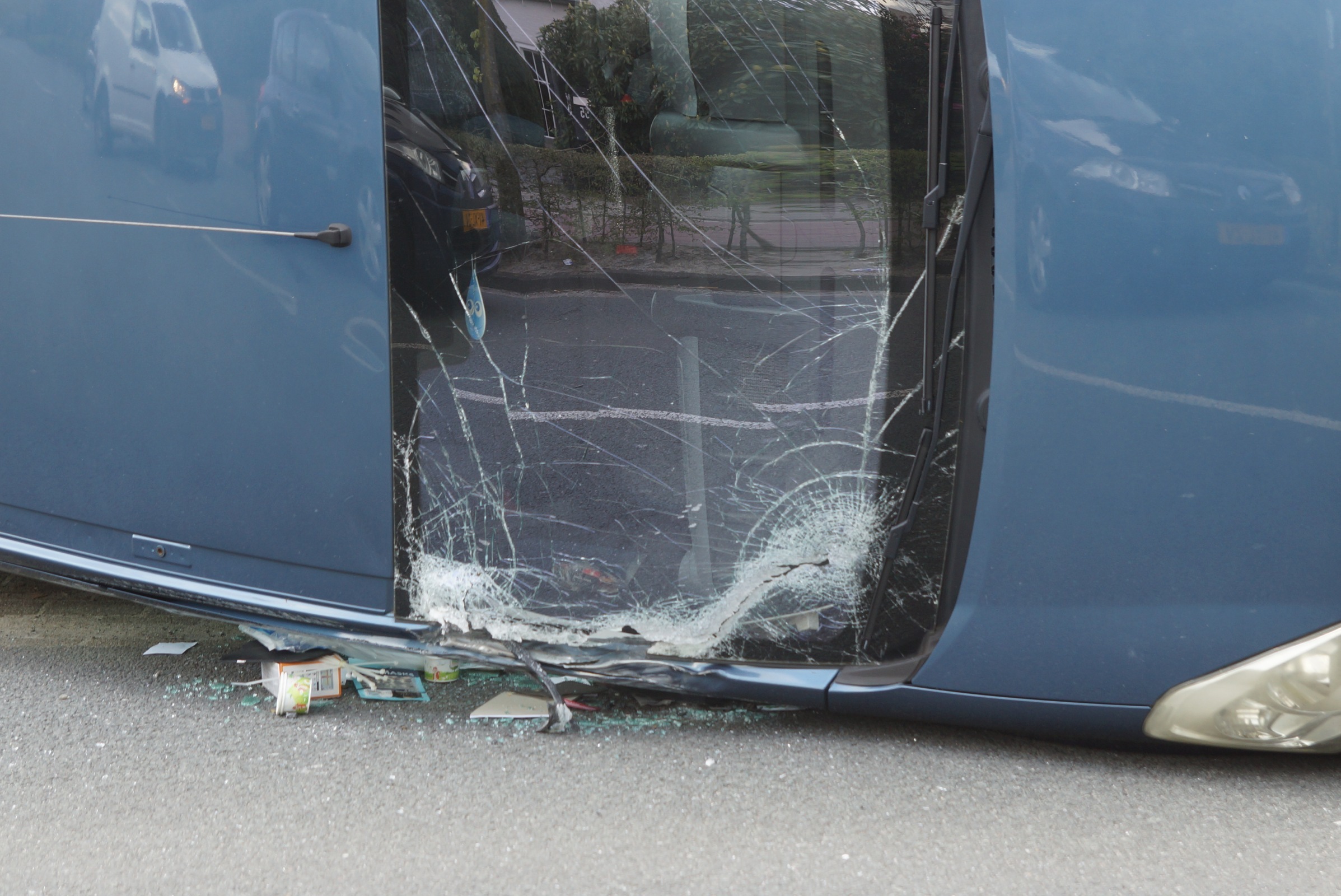 Geparkeerde auto belandt op zijn kant door openklappende vrachtwagendeur