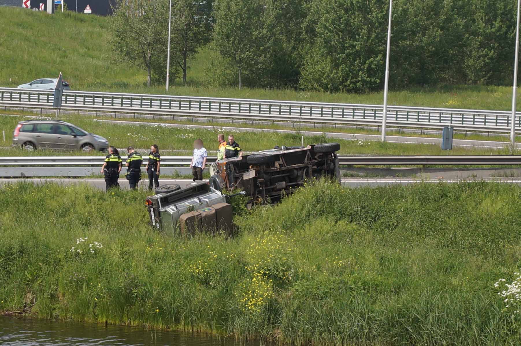 Auto met aanhanger komt op de zijkant terecht
