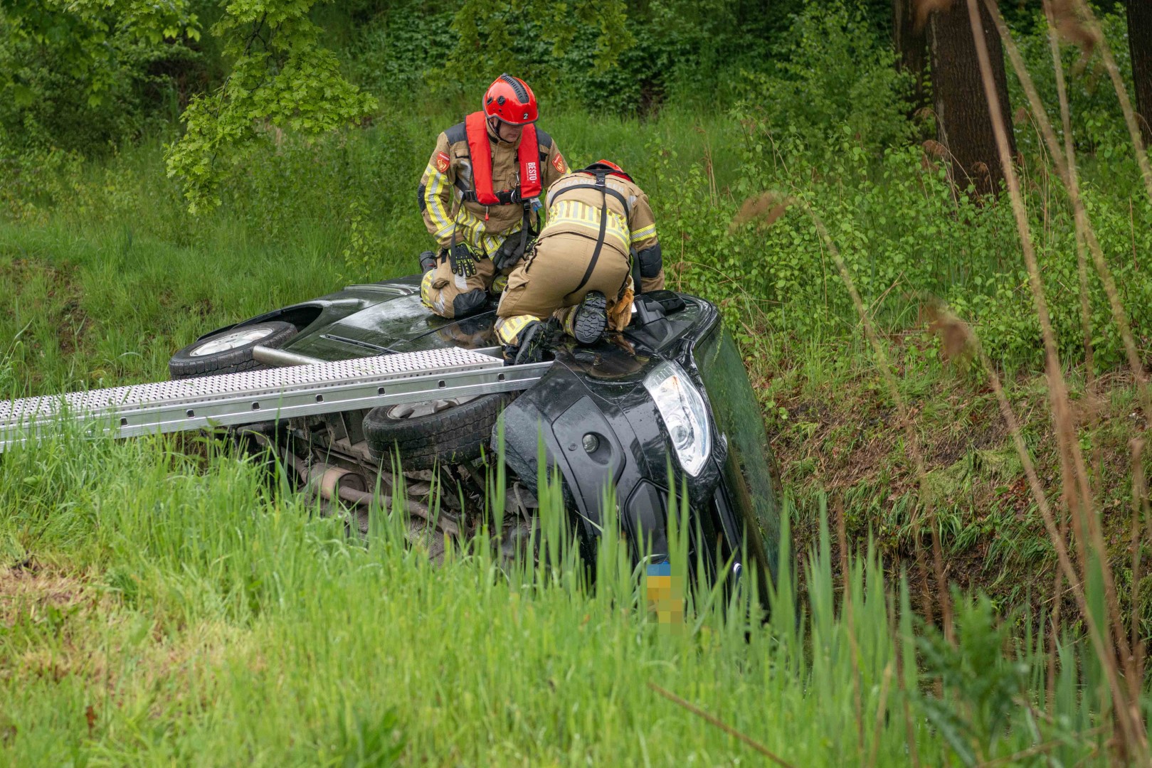 Bestelbus kantelt en beland in sloot