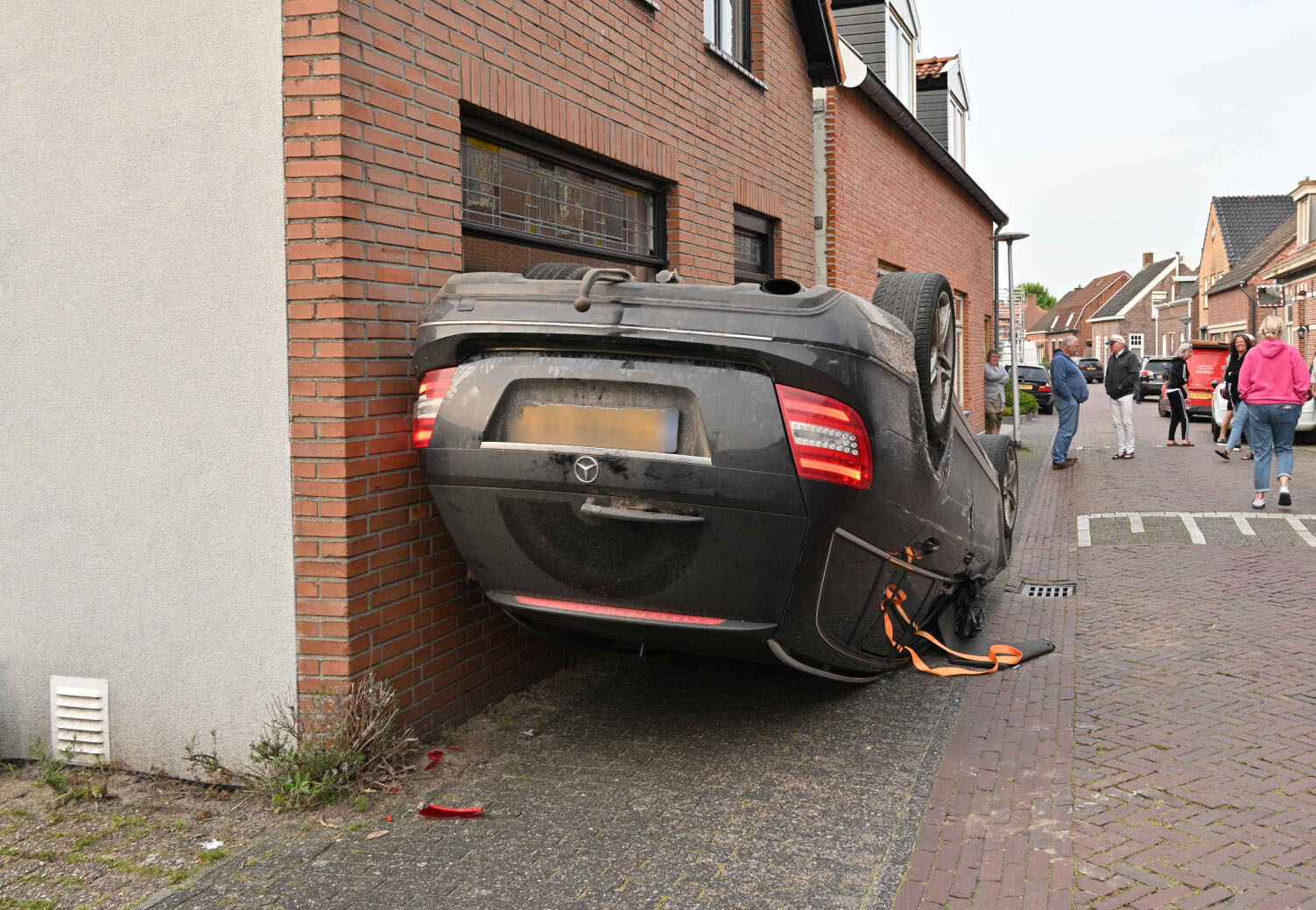 Auto slaat over de kop en komt tegen gevel van woning terecht