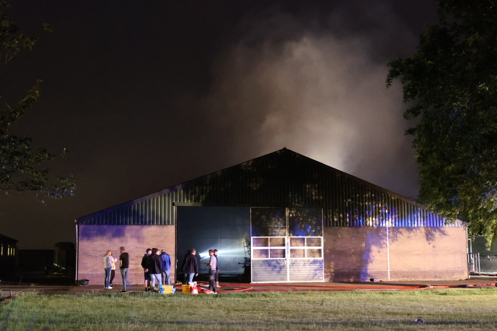Flinke brand in loods met landbouwmachines en hooi