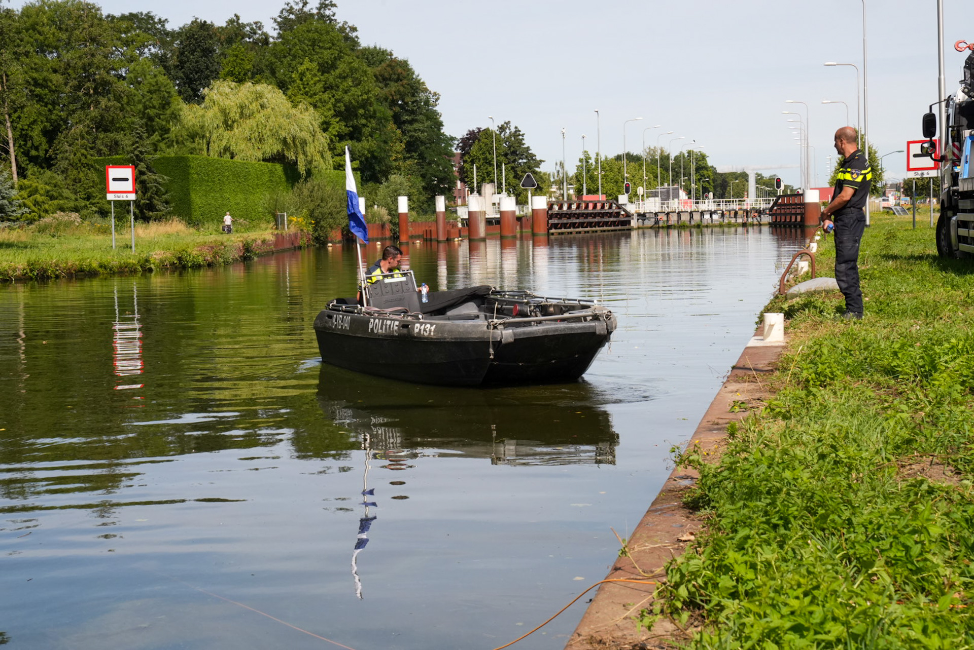 Politieduikers zoeken naar voorwerp in kanaal