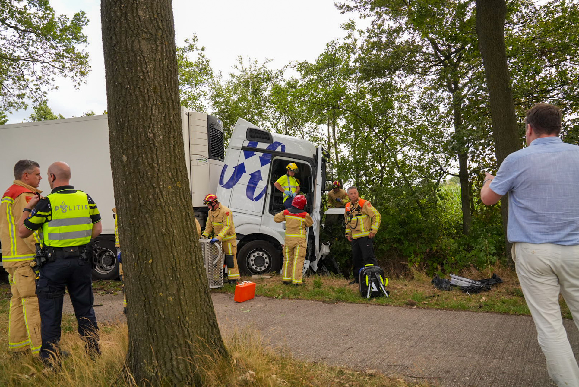 Vrachtwagenchauffeur bekneld na botsing met boom