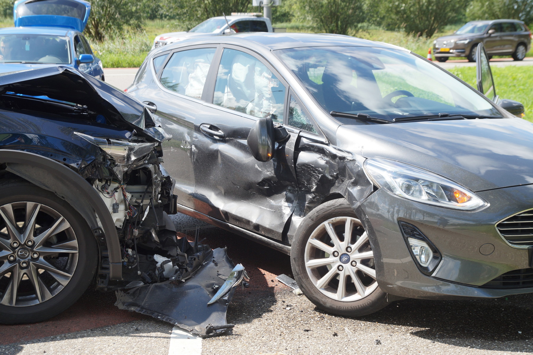 Voertuigen botsen hard op elkaar, veel schade en geschrokken bestuurders