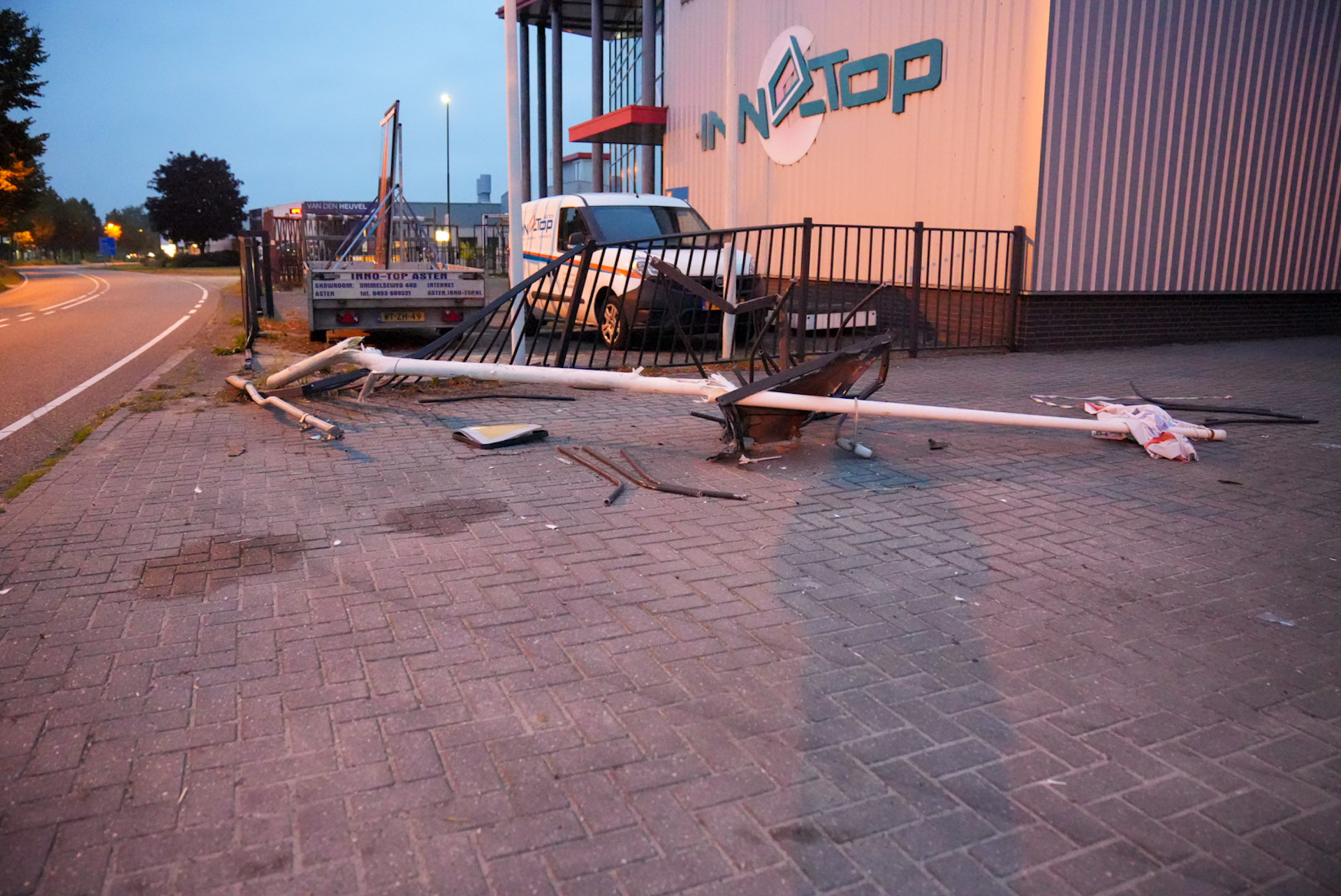 Busje ramt hekwerk en beland op zijkant voor bedrijfspand