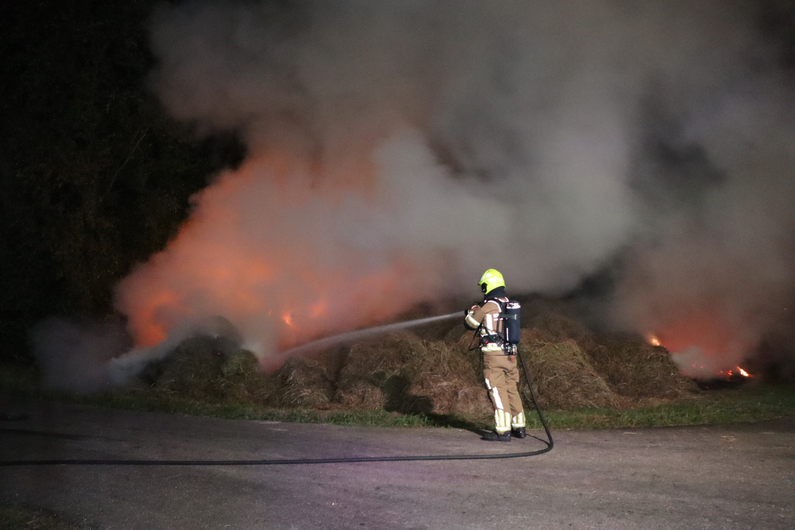 Grote berg hooi in brand, brandweer druk met blussen