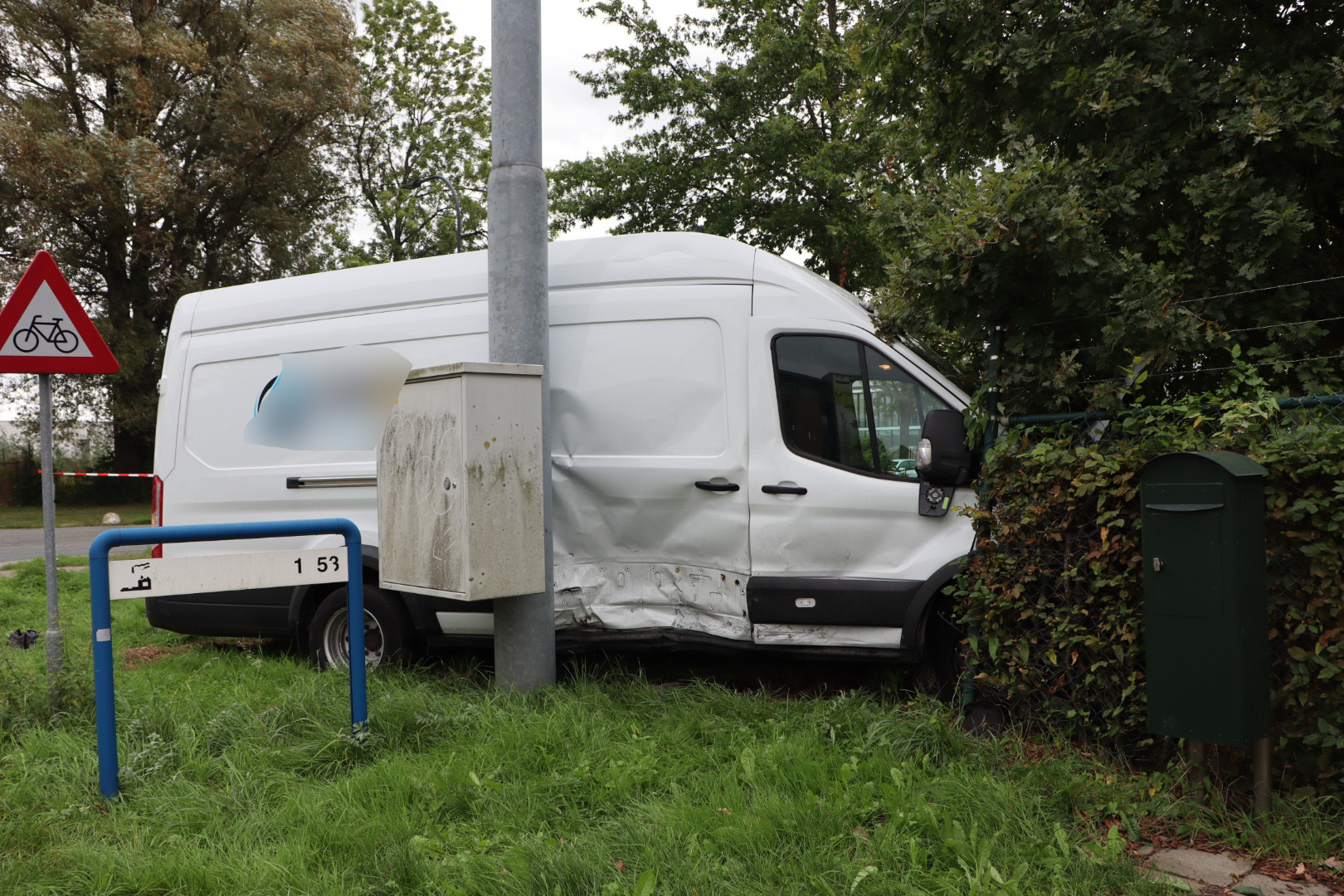 Twee voertuigen botsen, bestelbus eindigt tegen hekwerk