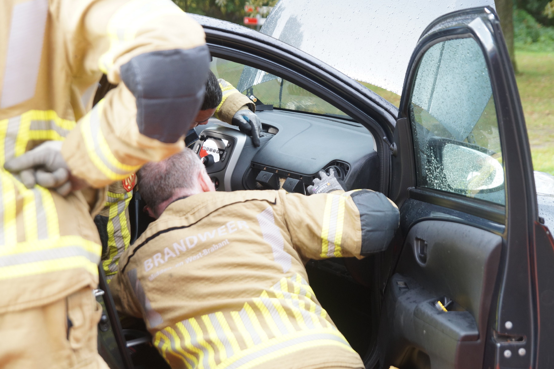 Katje vast achter dashboard van auto