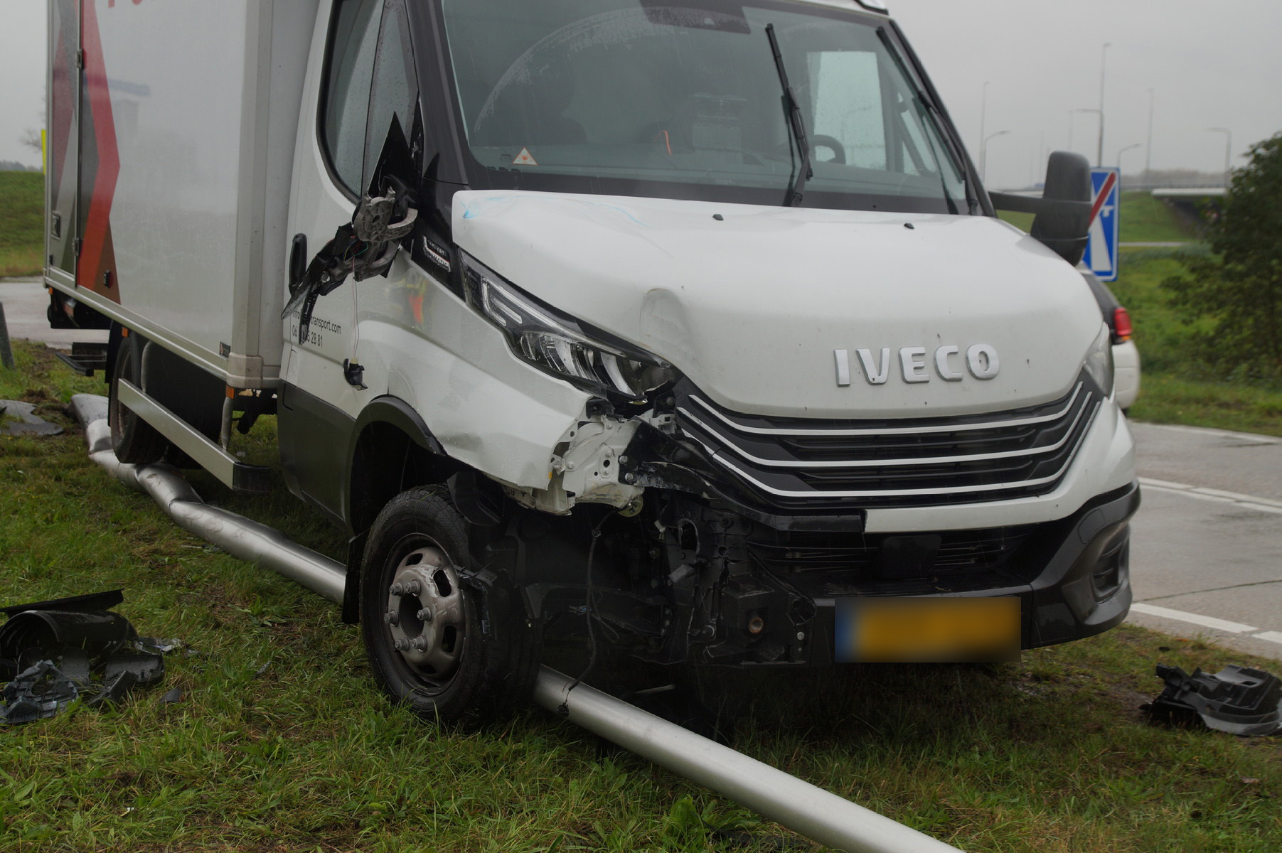 Bestelbus rijdt bord en lantaarnpaal uit de grond