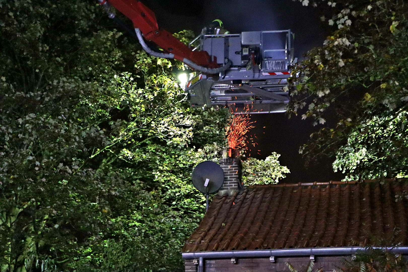 Vlammen en vonken slaan uit schoorsteen