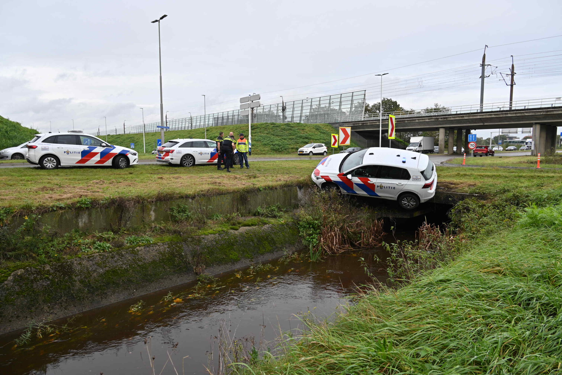 Politiewagen bungelt boven sloot, agenten ongedeerd