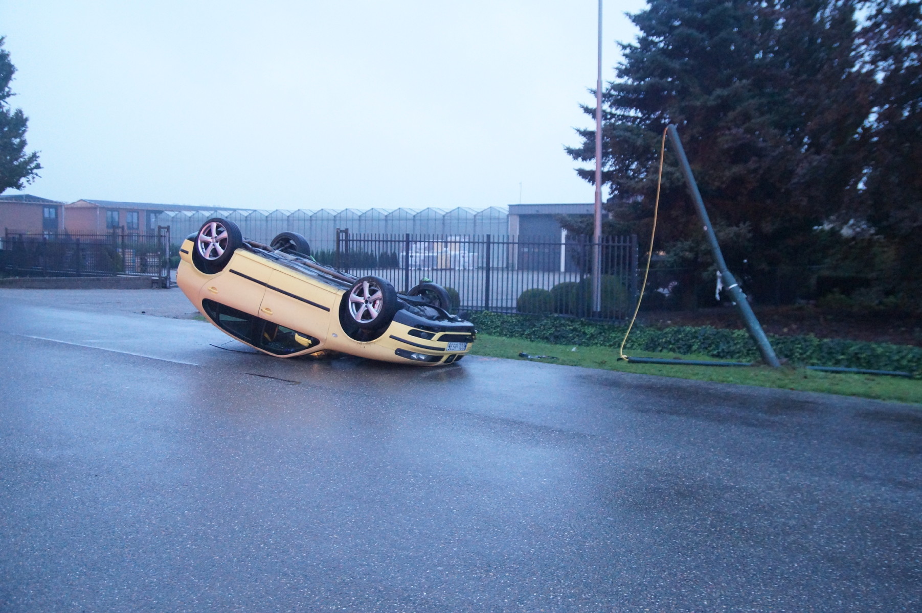 Auto botst tegen lantaarnpaal en belandt op z’n dak