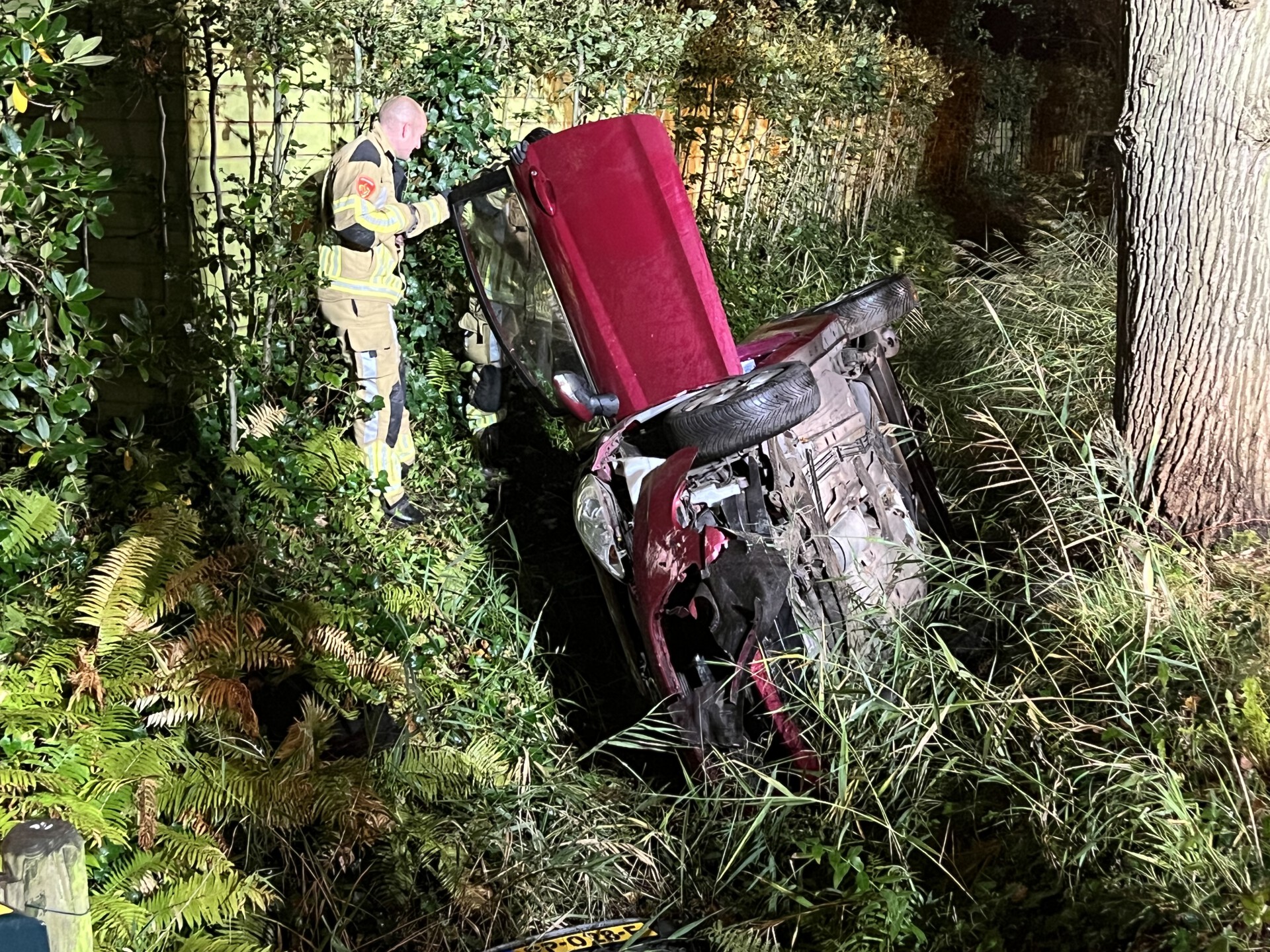 Auto belandt in sloot na crash met lantaarnpaal