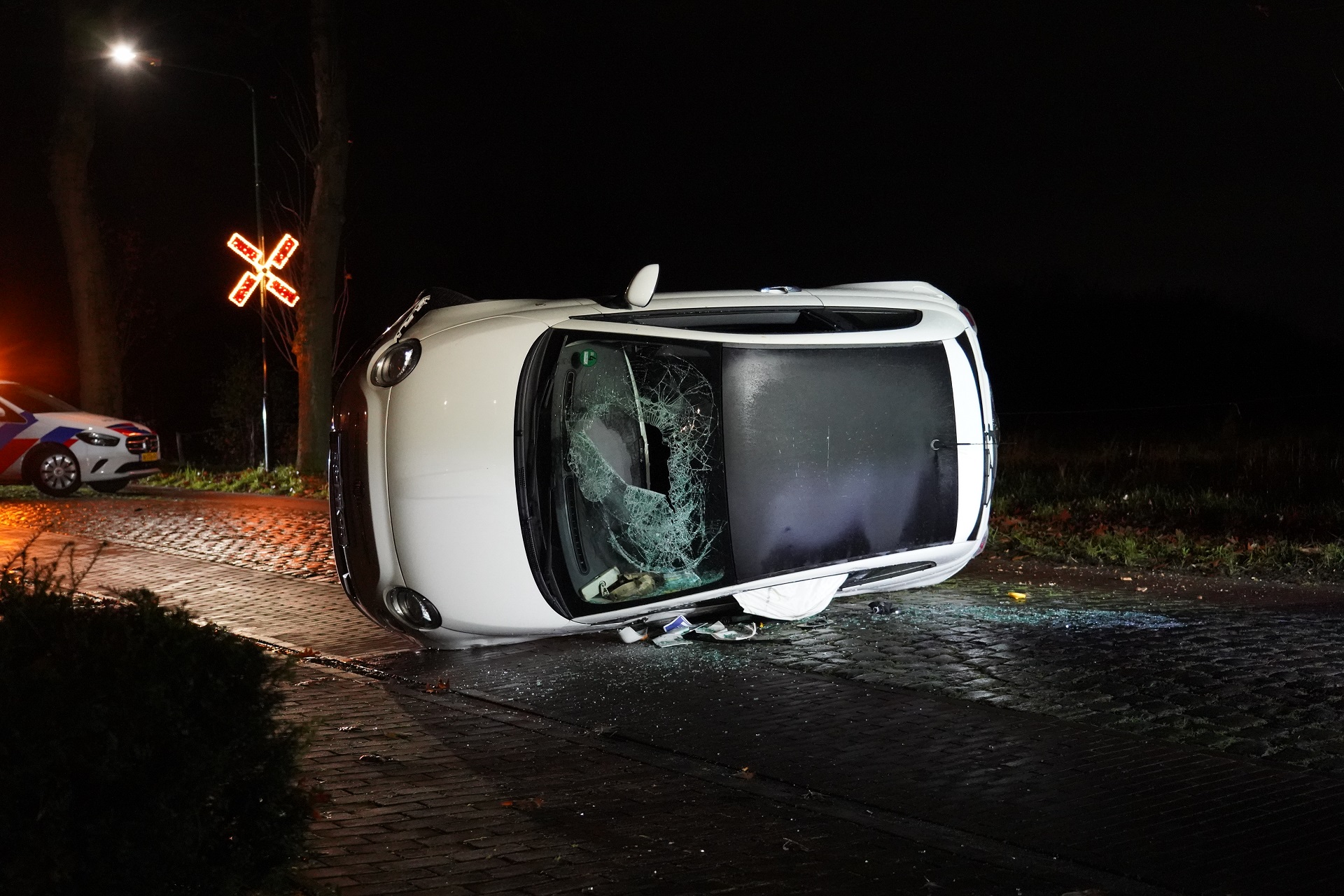 Auto belandt op z’n kant na botsing tegen boom