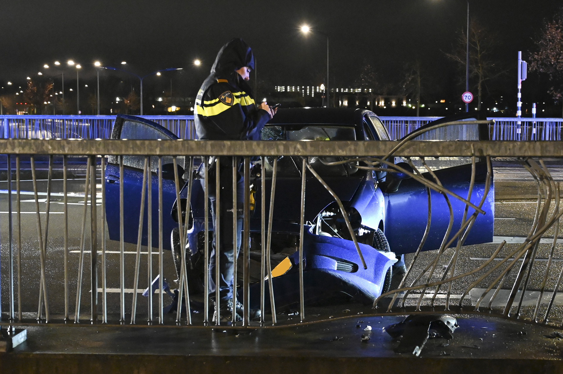 Auto ramt hekwerk op viaduct, bestuurder gewond