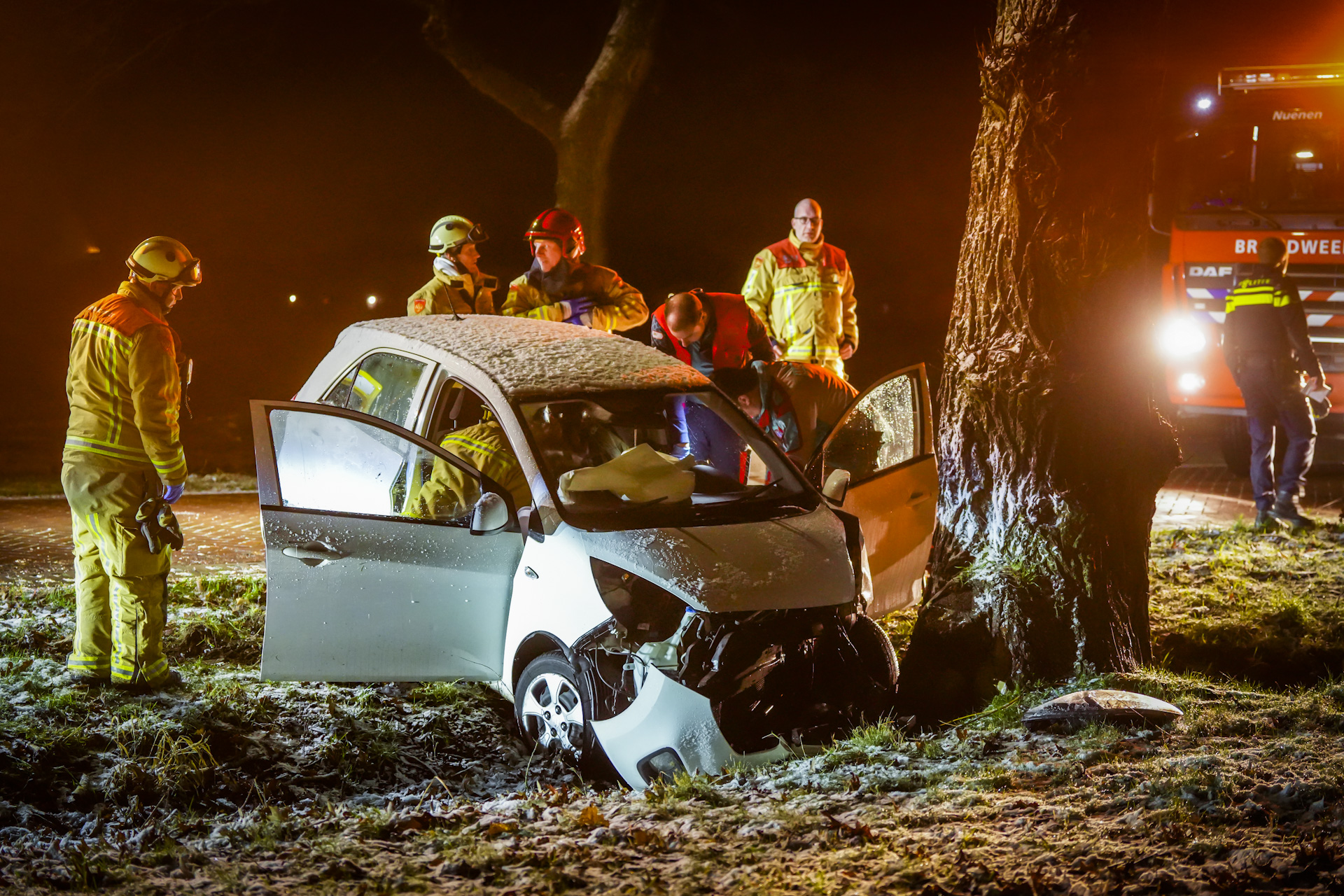 Auto botst tegen boom door spekgladde weg, automobiliste bekneld