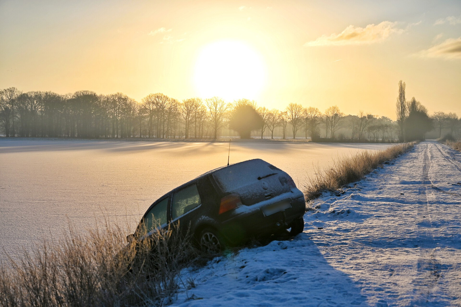 Auto schiet van besneeuwd pad en belandt in bevroren weiland