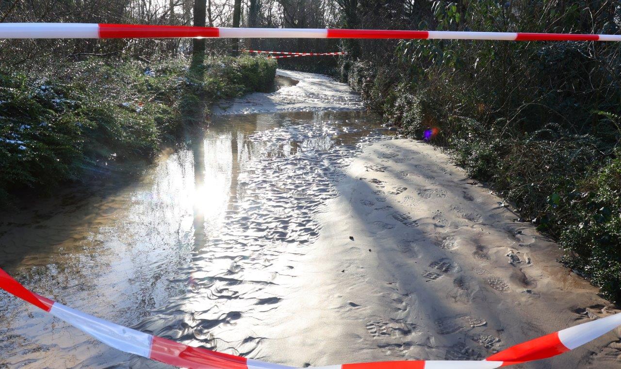 Tuinen, fietspaden en grasvelden onder water door gesprongen leiding