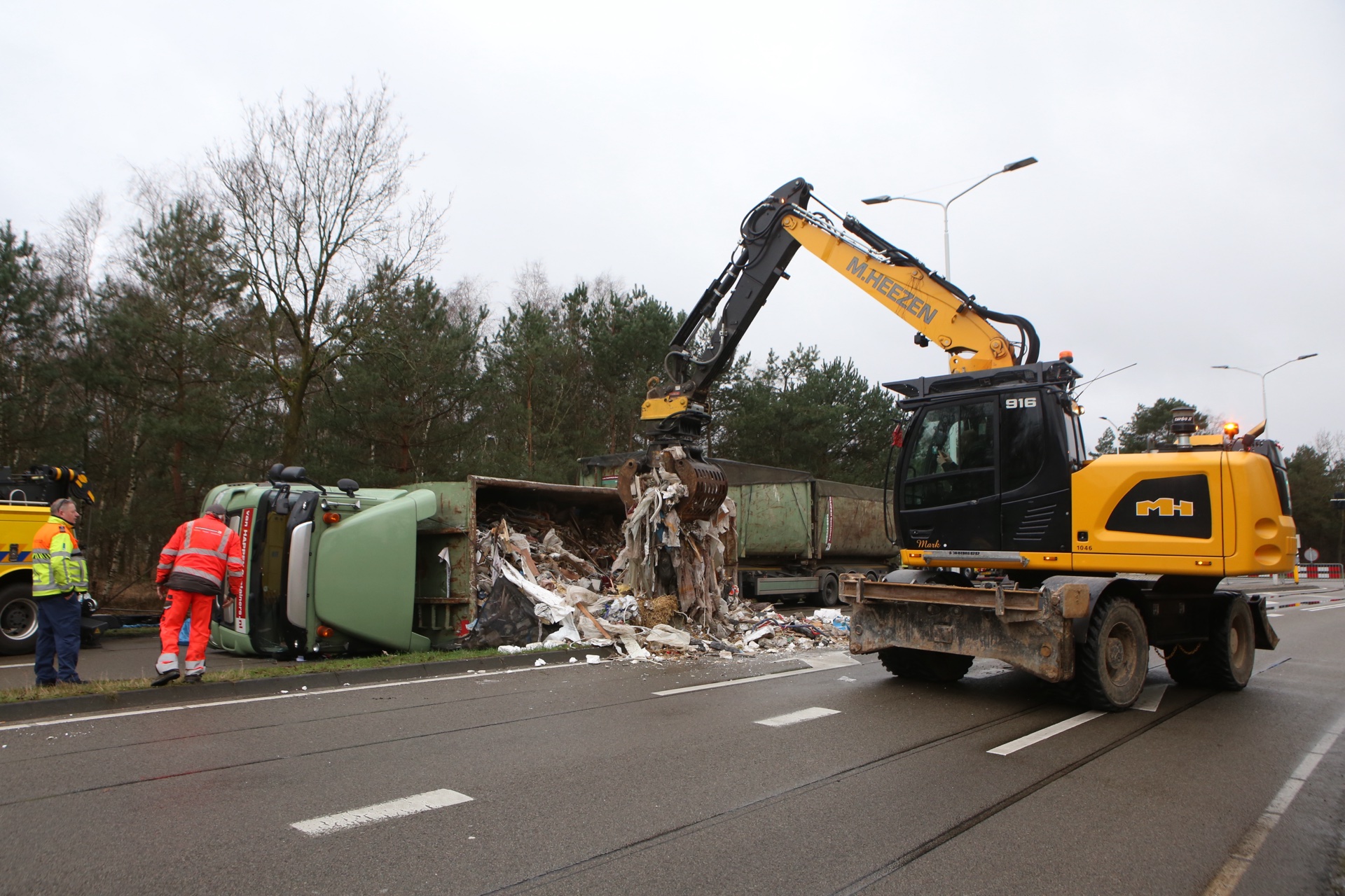 Vrachtwagen met afval kantelt, chauffeur ongedeerd