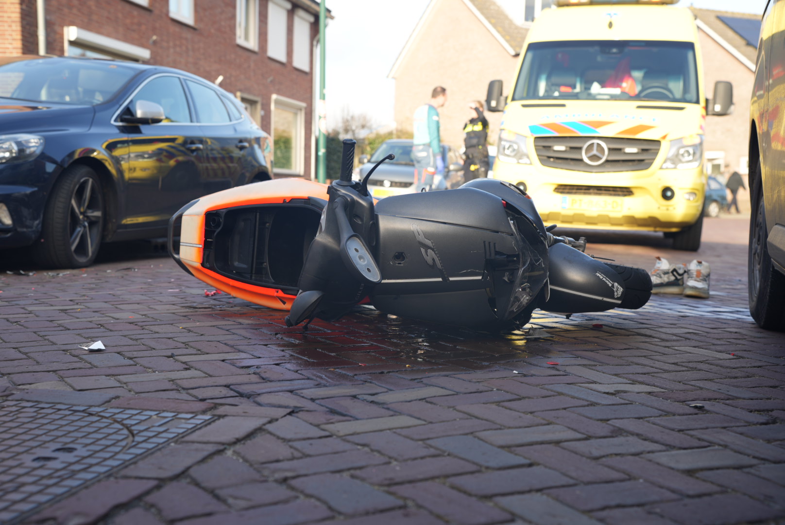Scooterrijder zonder helm wordt gelanceerd over drempel belandt tegen geparkeerde auto