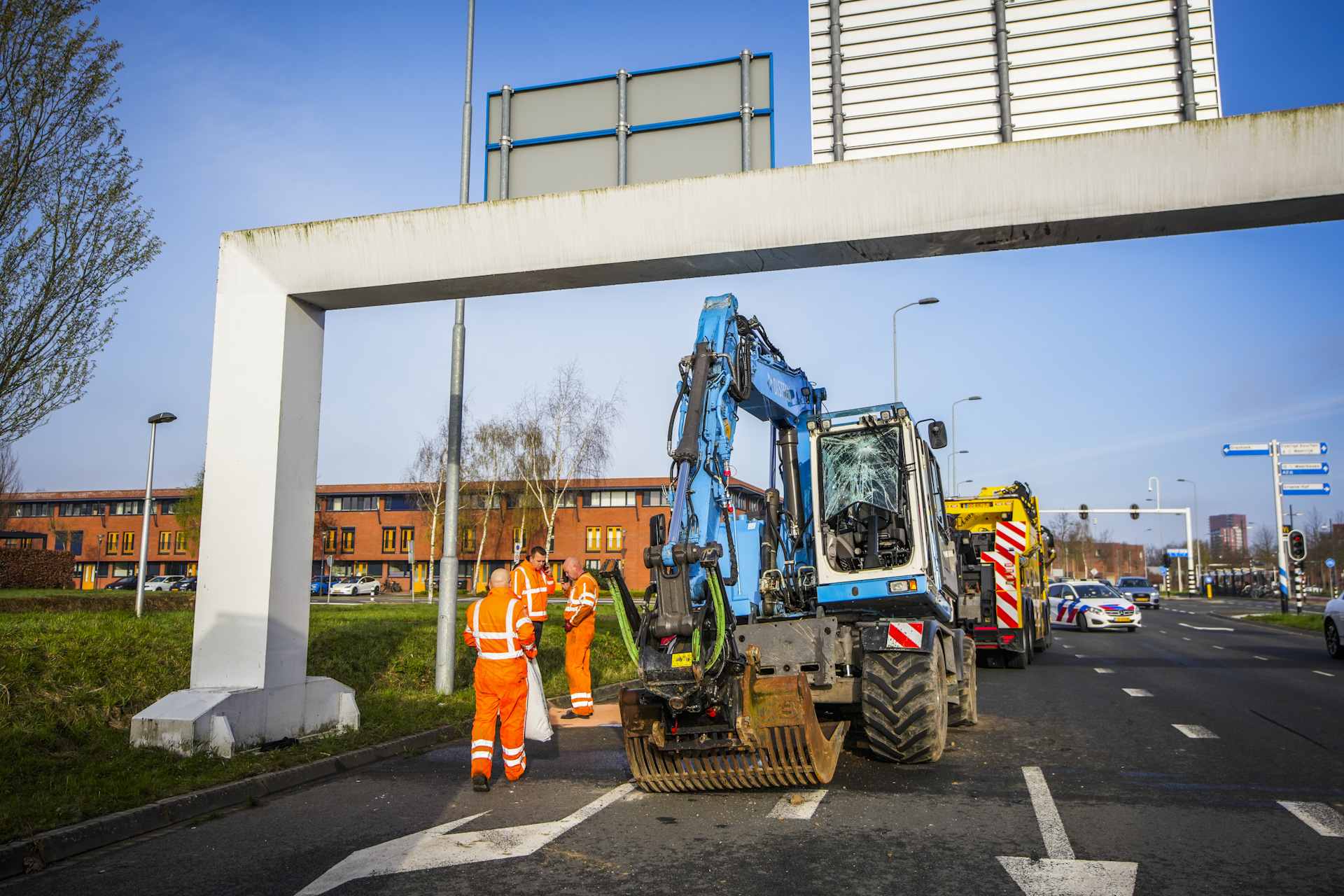 Graafmachine ramt portaal boven de weg, bestuurder gewond