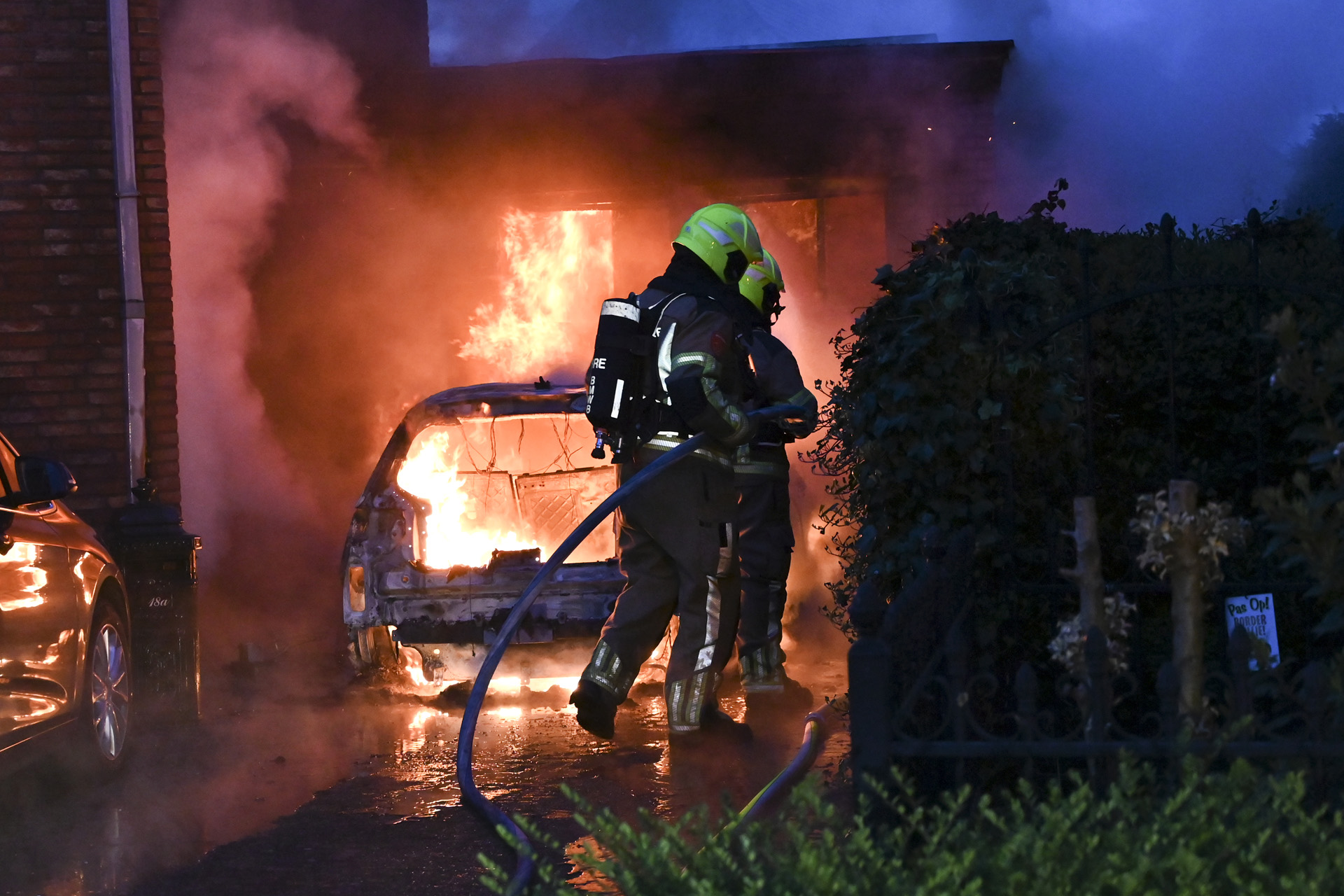 Elektrische auto vliegt in brand onder carport van woning