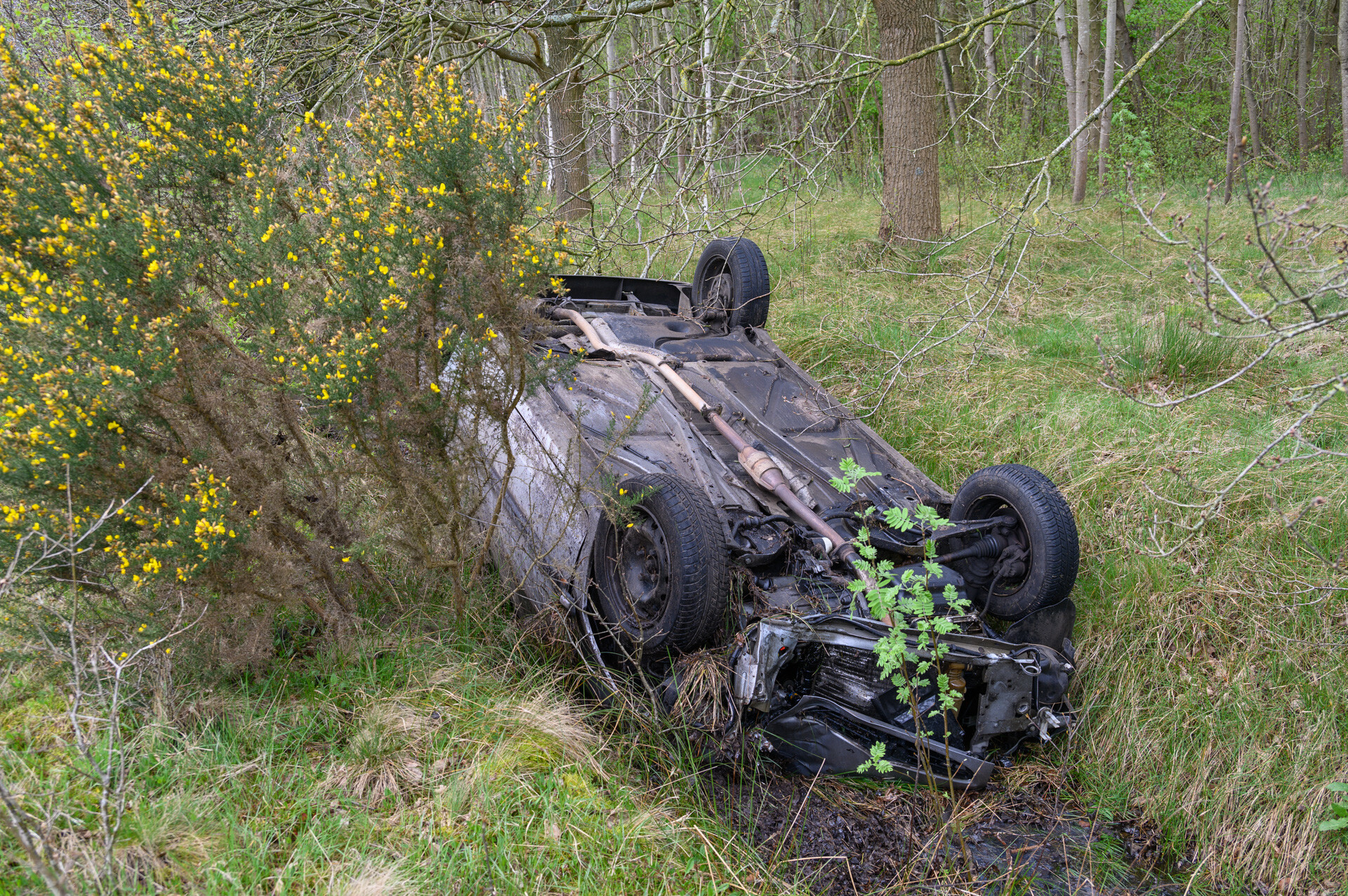 Auto op z’n kop in sloot, politie deelt bekeuringen uit voor negeren rood kruis