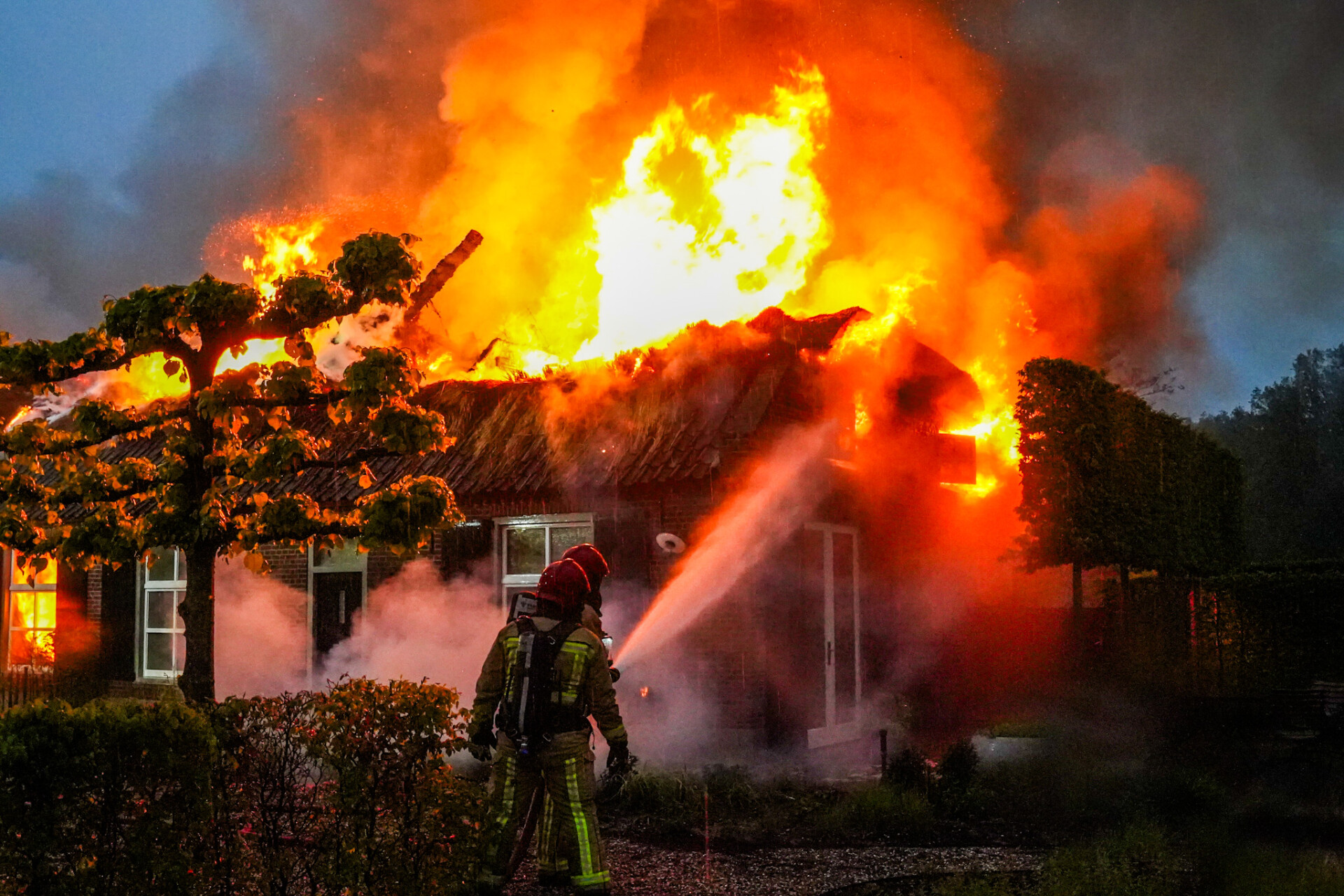 Grote brand in woning met rieten dak, mogelijk door blikseminslag