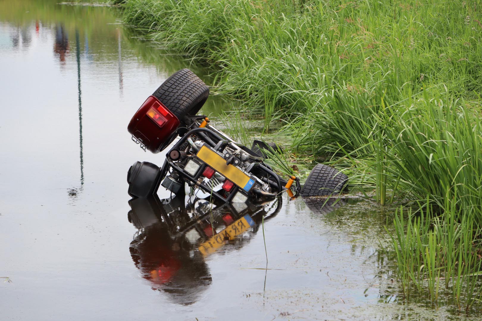 Vrouw met kind rijdt Trike de sloot in