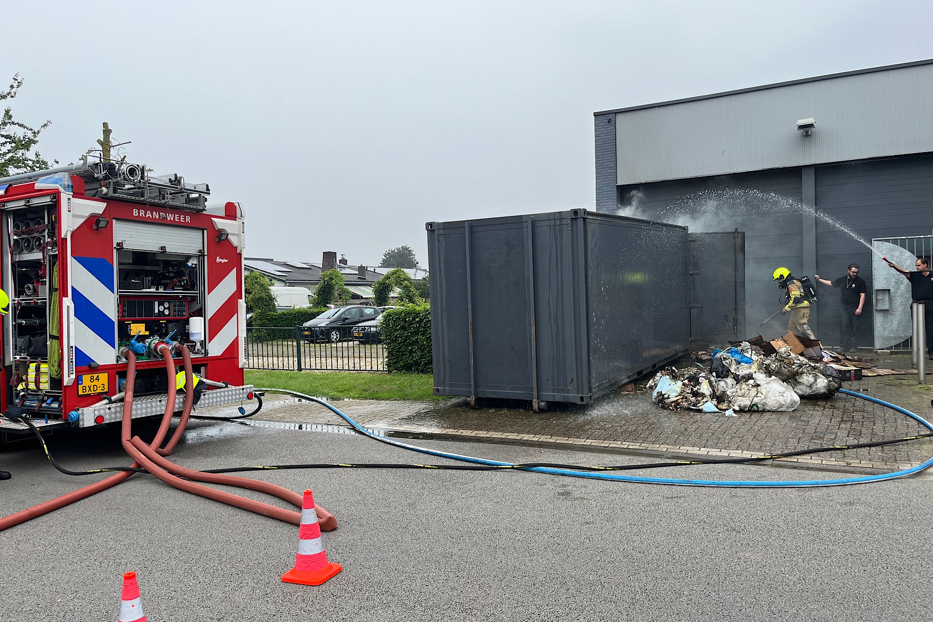 Container met papier en plastic afval vliegt in brand bij bedrijf