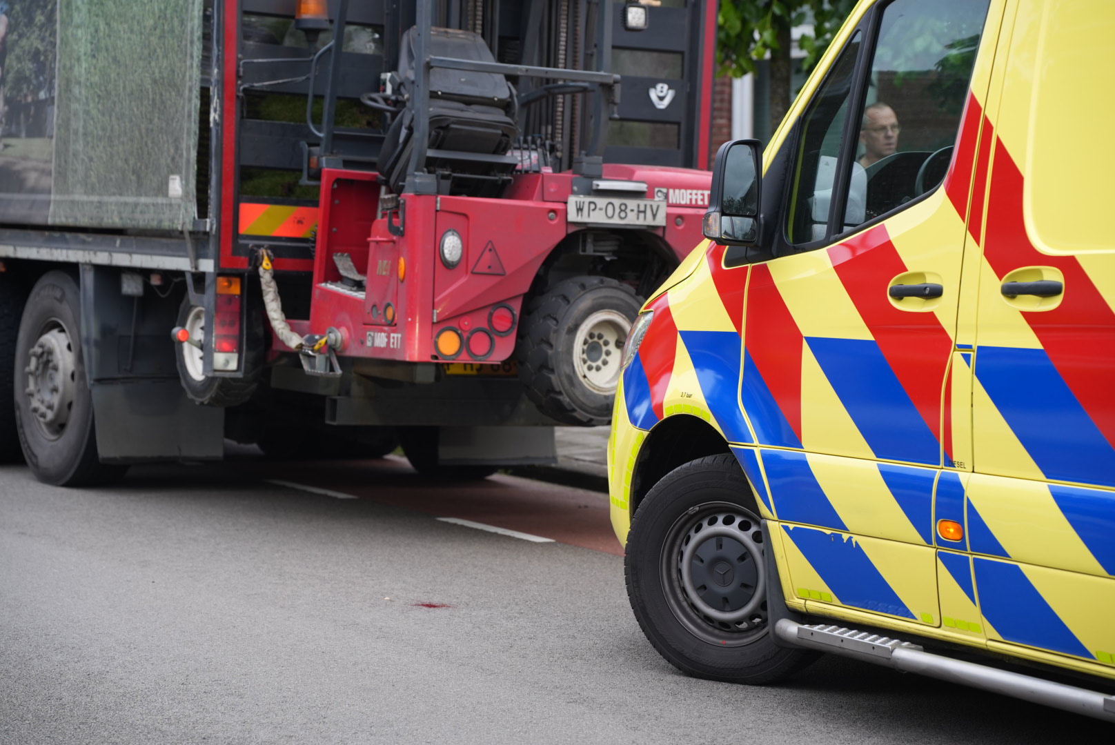 Meisje fietst met telefoon in haar hand tegen achterkant van vrachtwagen