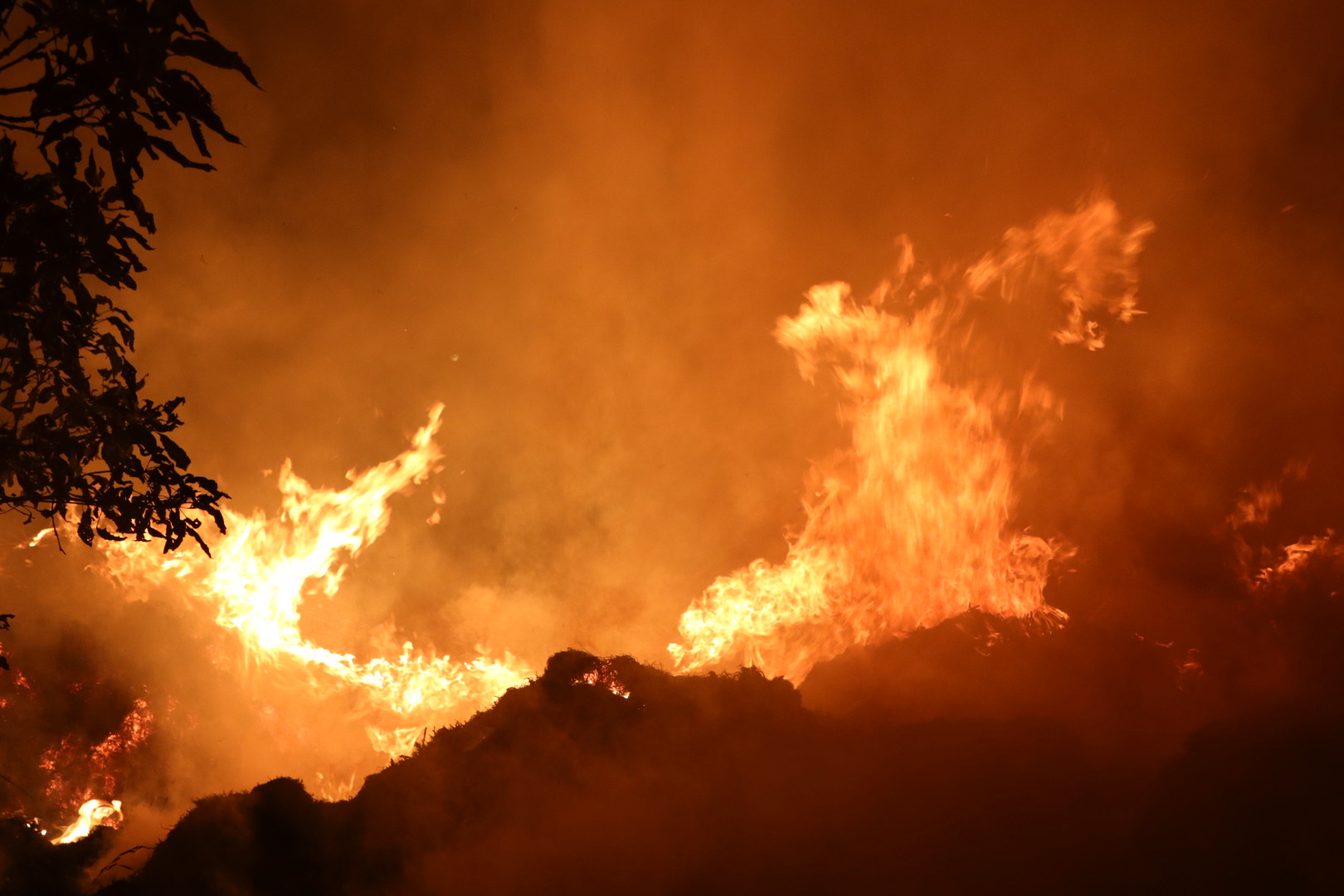 Enorme vlammenzee door berg met gras in brand