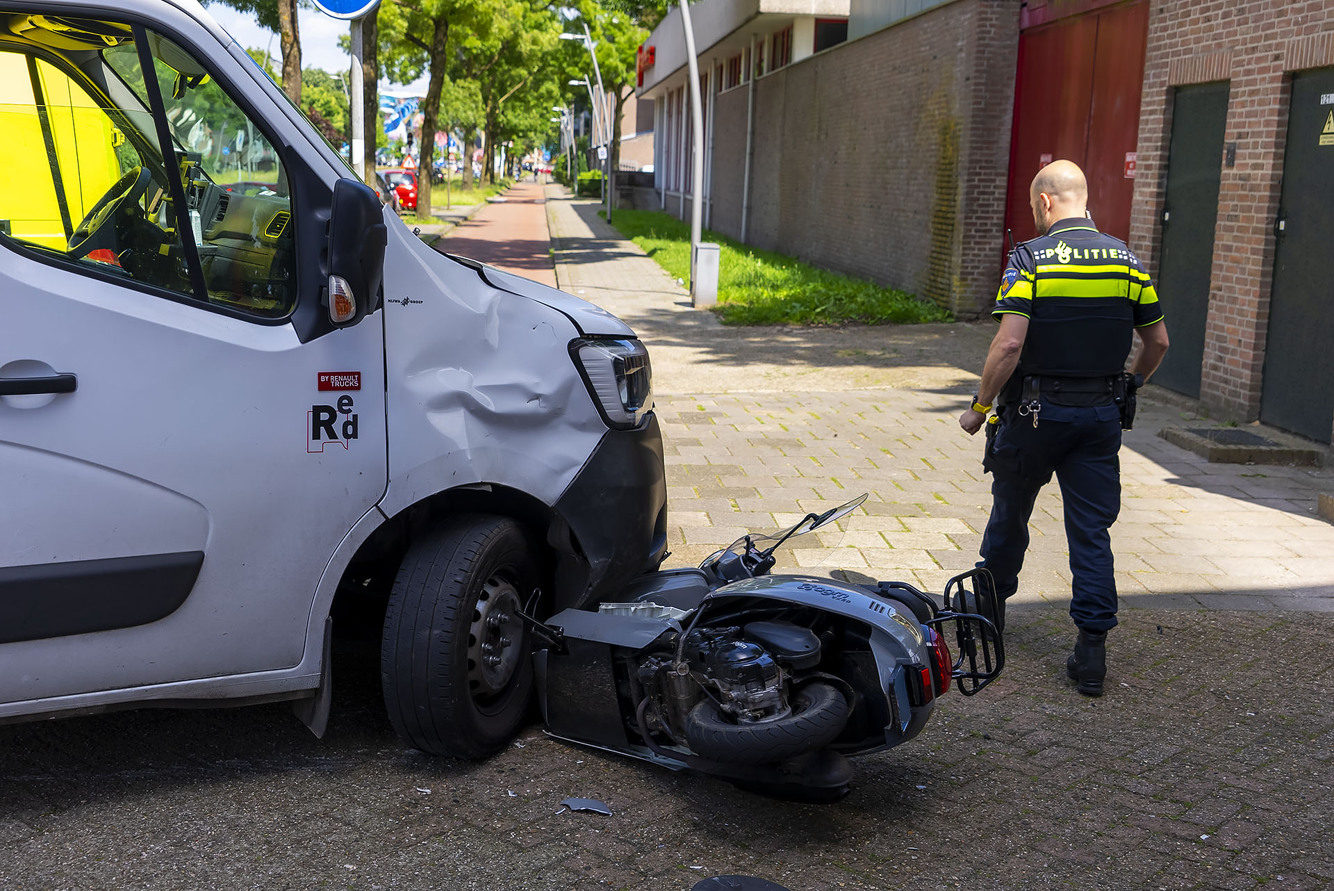Scooter belandt onder bakwagen, bestuurder lichtgewond