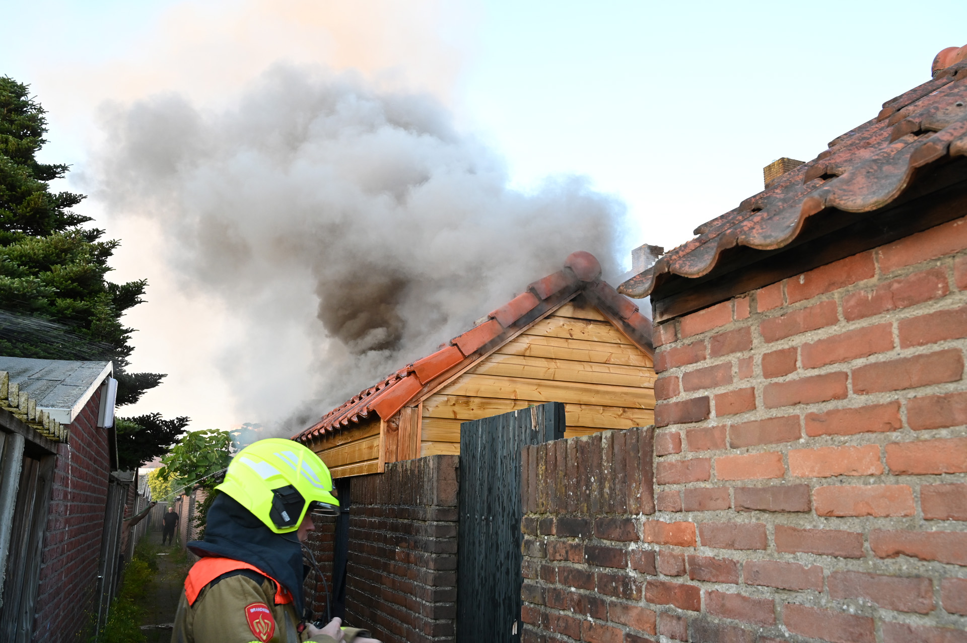 Schuur achter woning vliegt in brand, bewoner ademt rook in