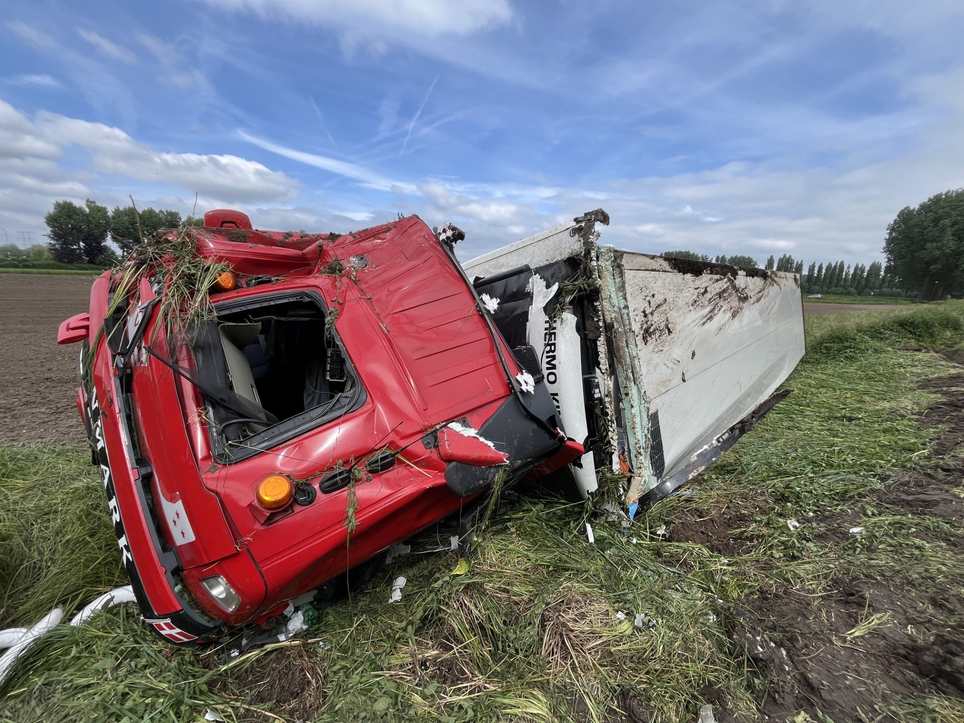 Vrachtwagen met zalmzijdes raakt van snelweg en rolt naar beneden