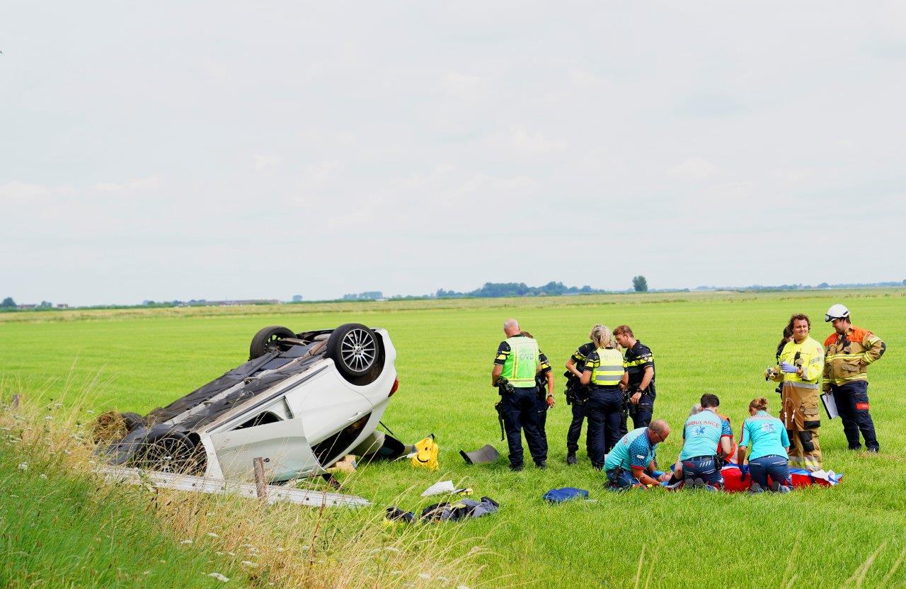 Auto ramt boom en belandt in weiland, vrouw gewond