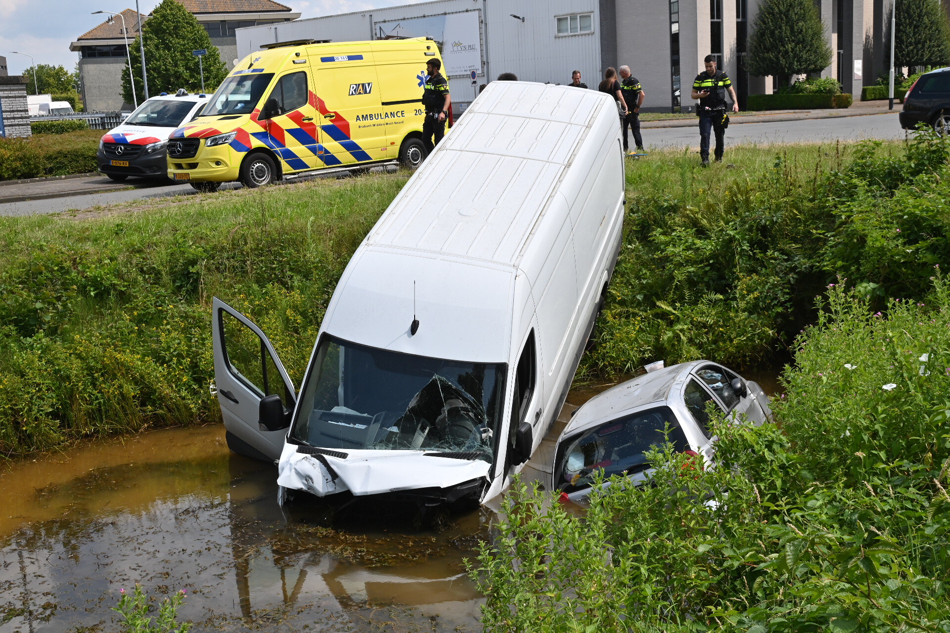 Pakketbezorger en auto belanden in water na botsing