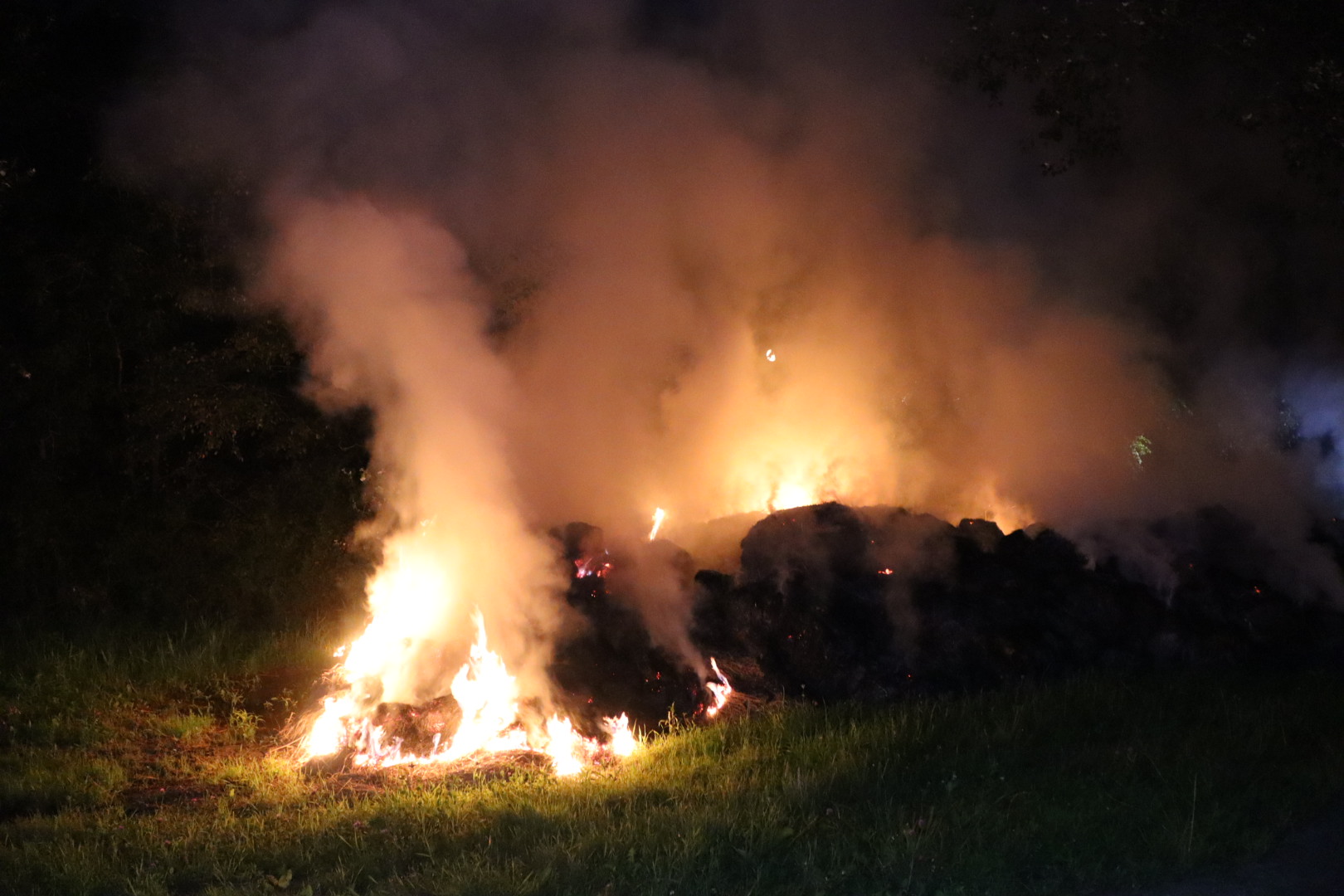 Berg met gemaaid gras vliegt in brand