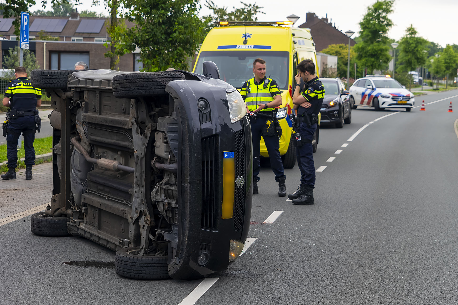 Auto op z’n kant na botsing tegen geparkeerde auto