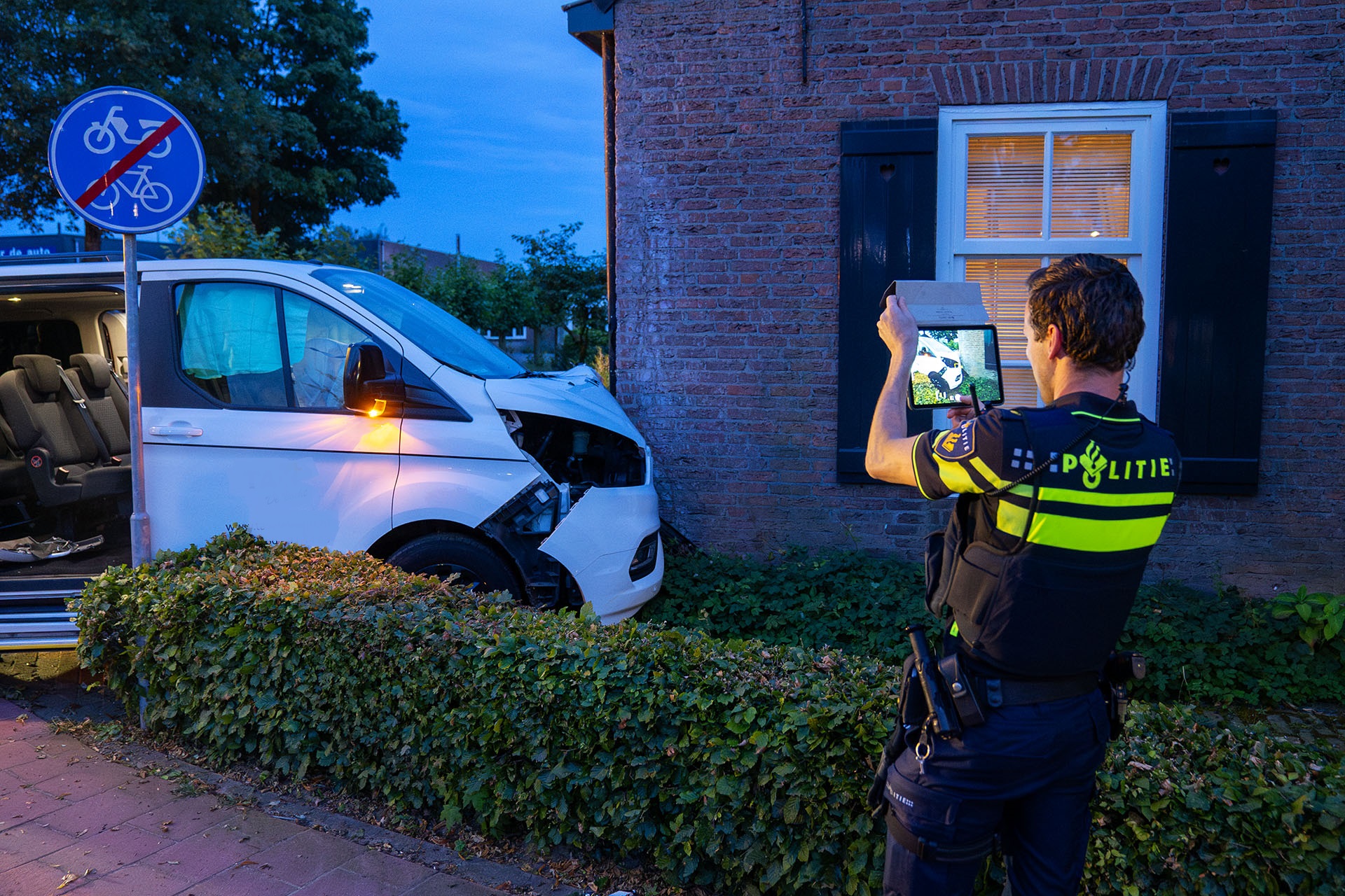 Taxibusje ramt woning, bestuurder gewond naar ziekenhuis