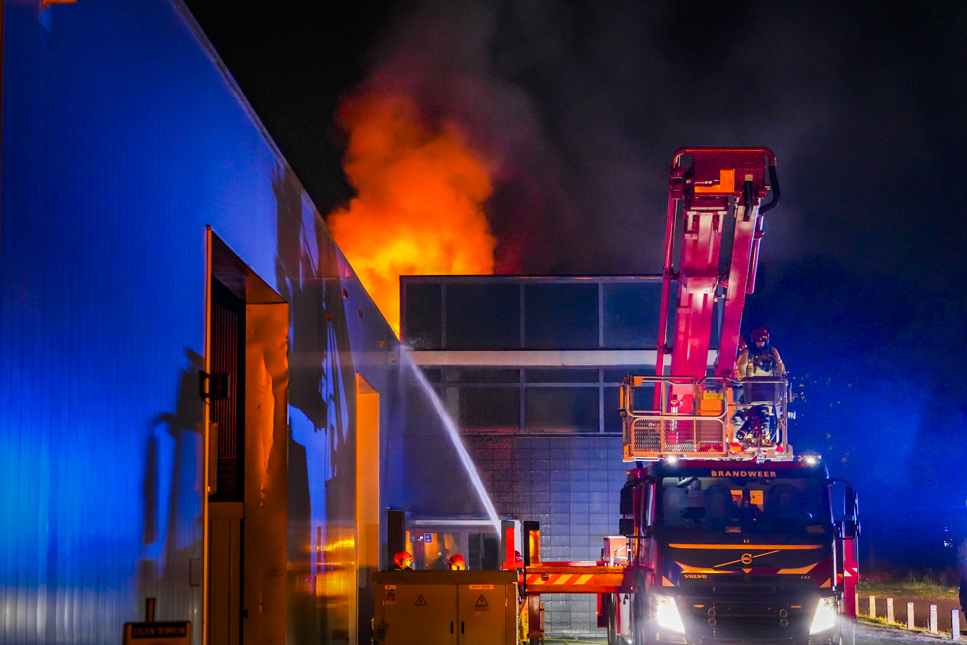 Brand op dak bedrijfsgebouw, vlammen ver in de omtrek te zien