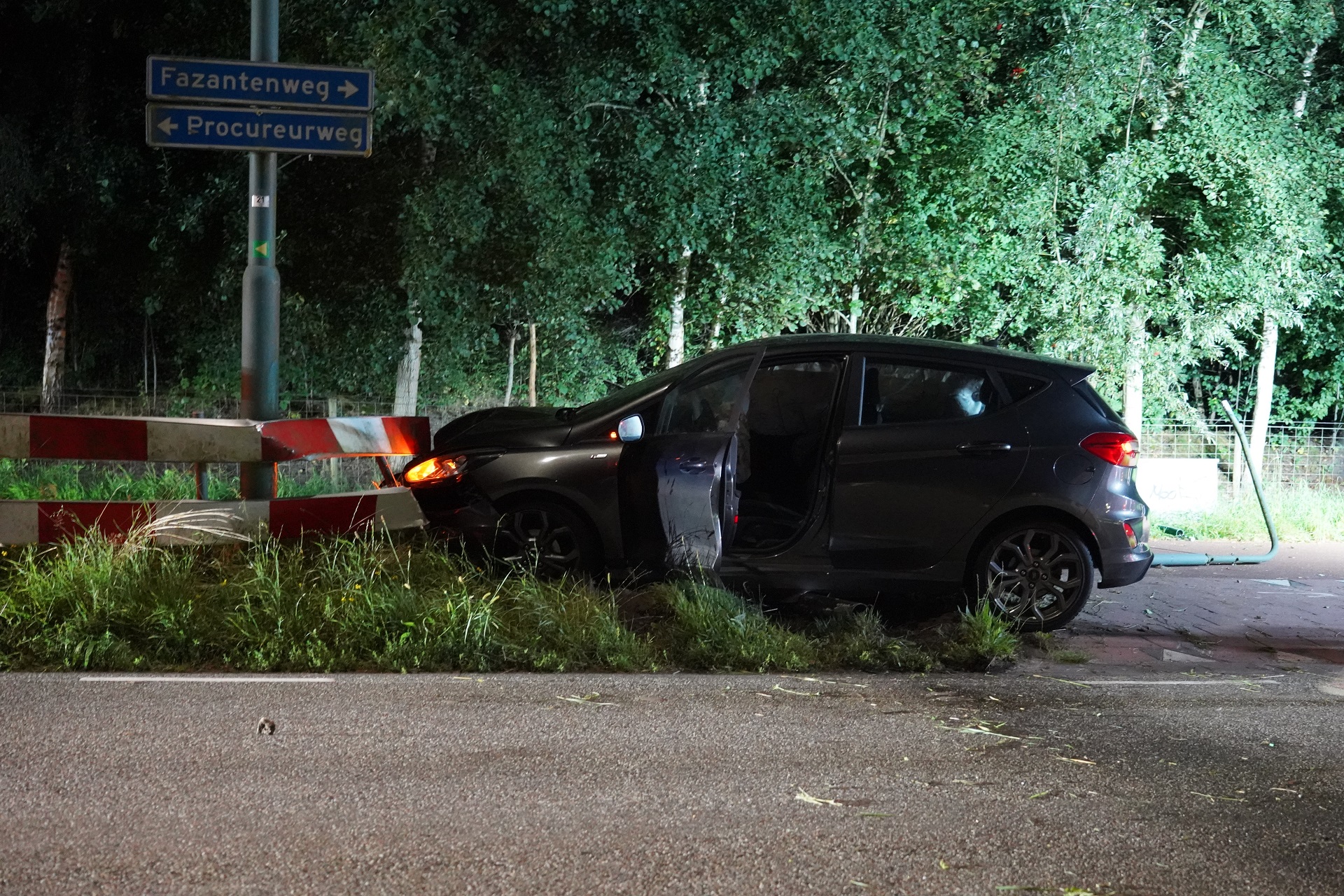 Automobilist ramt lantaarnpaal en verkeersbord
