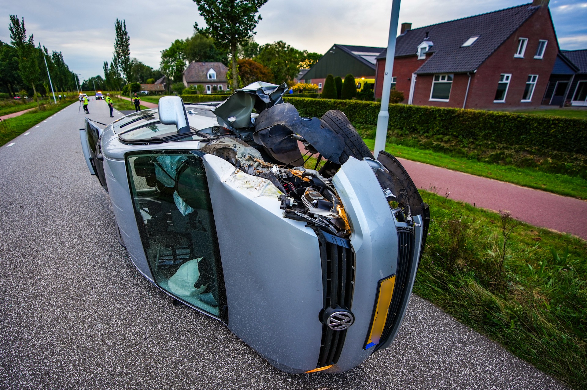 Auto met opa, oma en kleinkinderen ramt boom en belandt op zijn kant