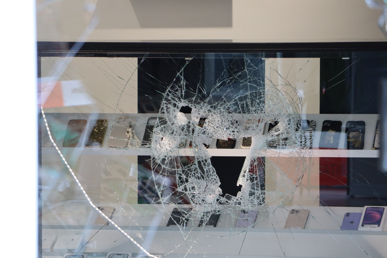 Ramen en vitrines kapot geslagen tijdens gewapende overal op telefoonwinkel